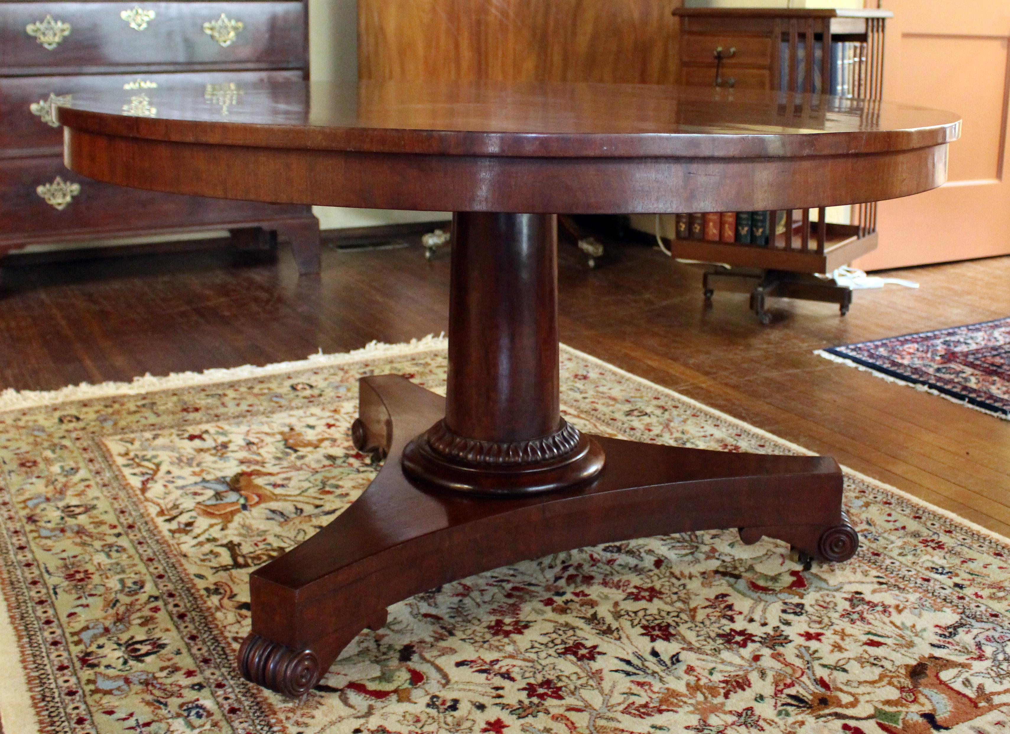 Early 19th century Regency to George IV tilt-top center table or loo table. Stamped Gillows. English. Mahogany. Plum pudding mahogany top of great figure. Rich mahogany base with acanthus ring carving. Tripod base raised on rosette accented,