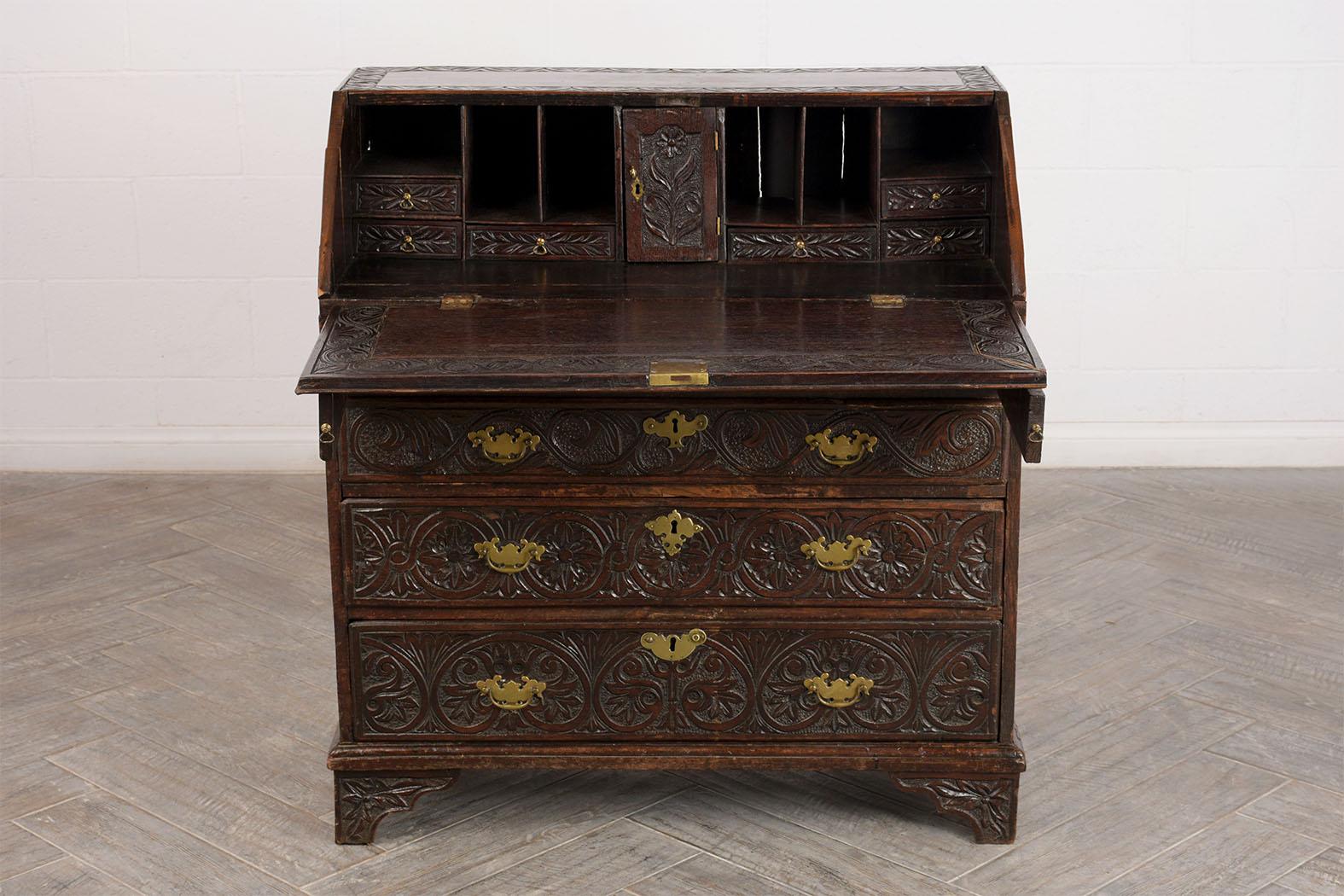 This 1830s English Slant Front Secretary Desk is made of walnut wood with the original finish and is in good condition. This drop Front Desk has elegant hand carvings on the drop top and drawers, two arms extend from the front of the desk to support