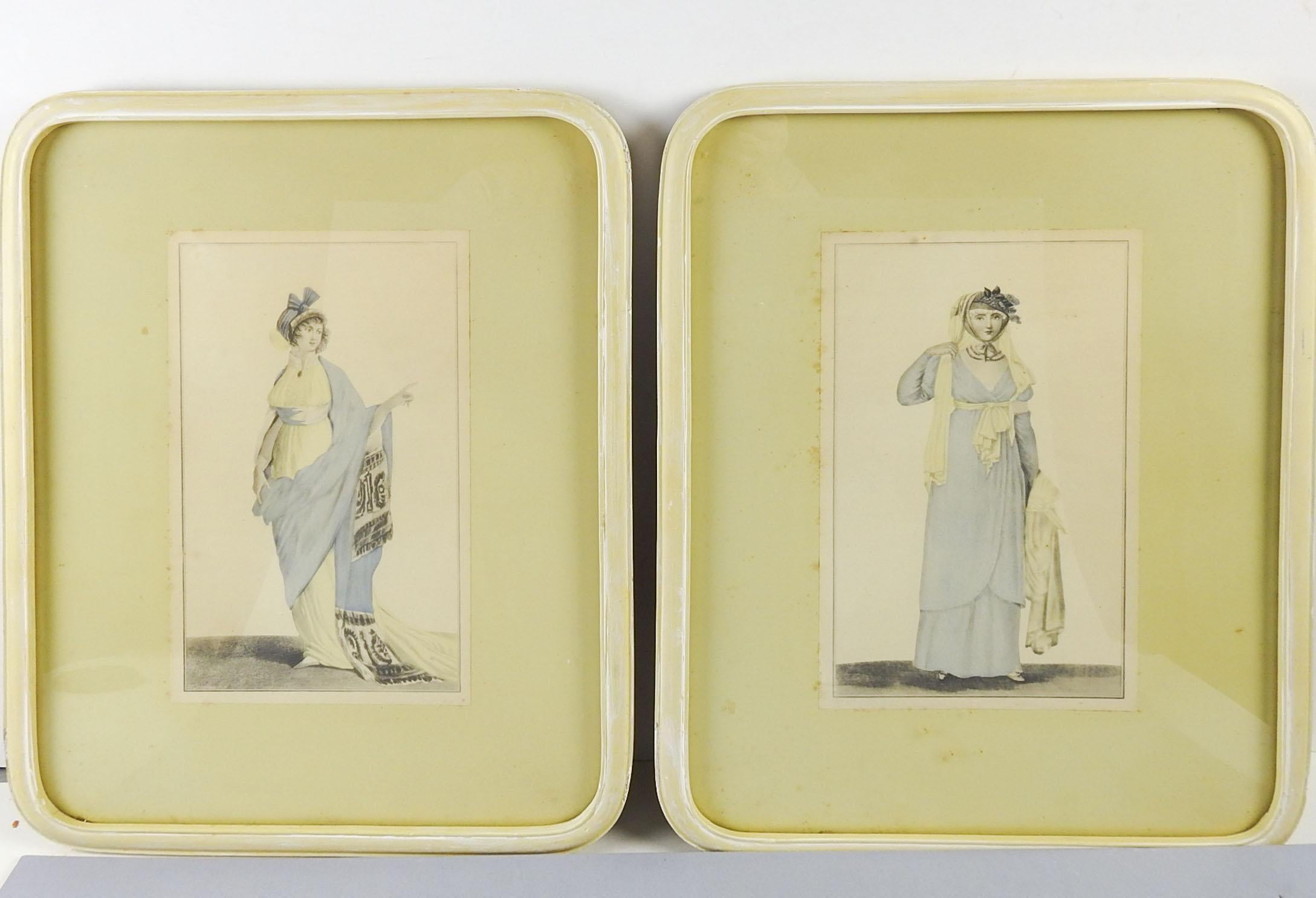 Pair of Regency era fashion plates, circa 1810 blue and yellow gowns. Displayed in custom round cornered painted yellow frames, mounted to mat board under glass. Age toning, foxing to mat, scuffing to frames.