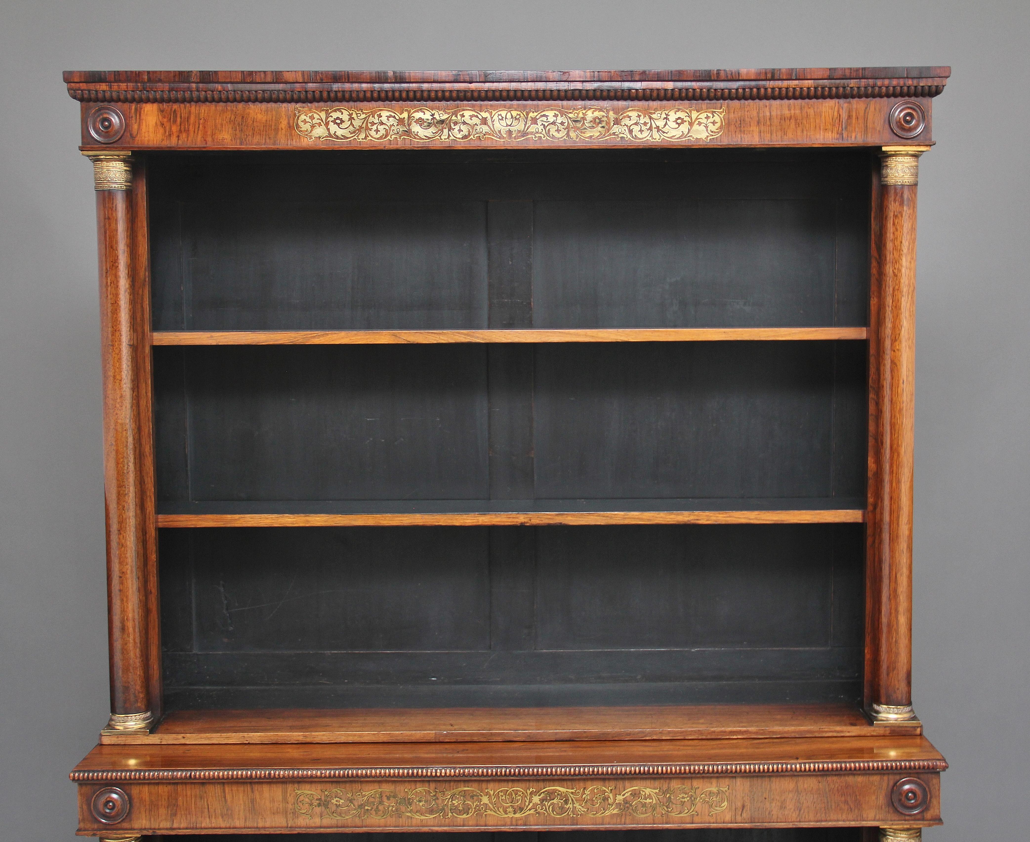 Early 19th century rosewood and brass inlaid open bookcase, the moulded edge top having carved beading running along the front and sides, wonderful brass inlaid pattern on the top and bottom frieze, turned columns decorated with brass capitals,