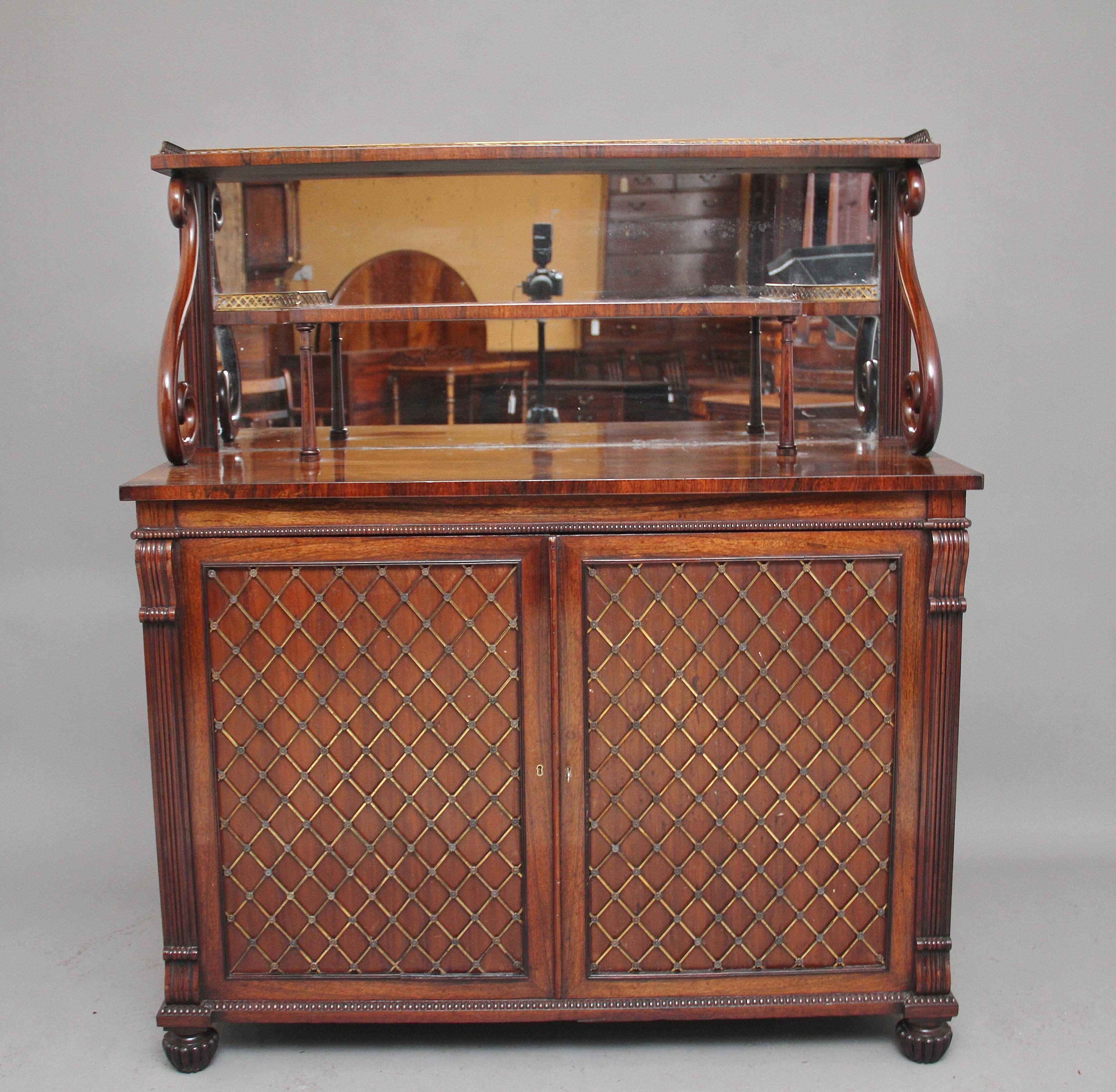 Early 19th century rosewood two tier cabinet of exceptional quality, the top tier having a pierced brass gallery running along the back and sides, the shaped tier below also decorated with a pierced brass gallery and supported on finely turned