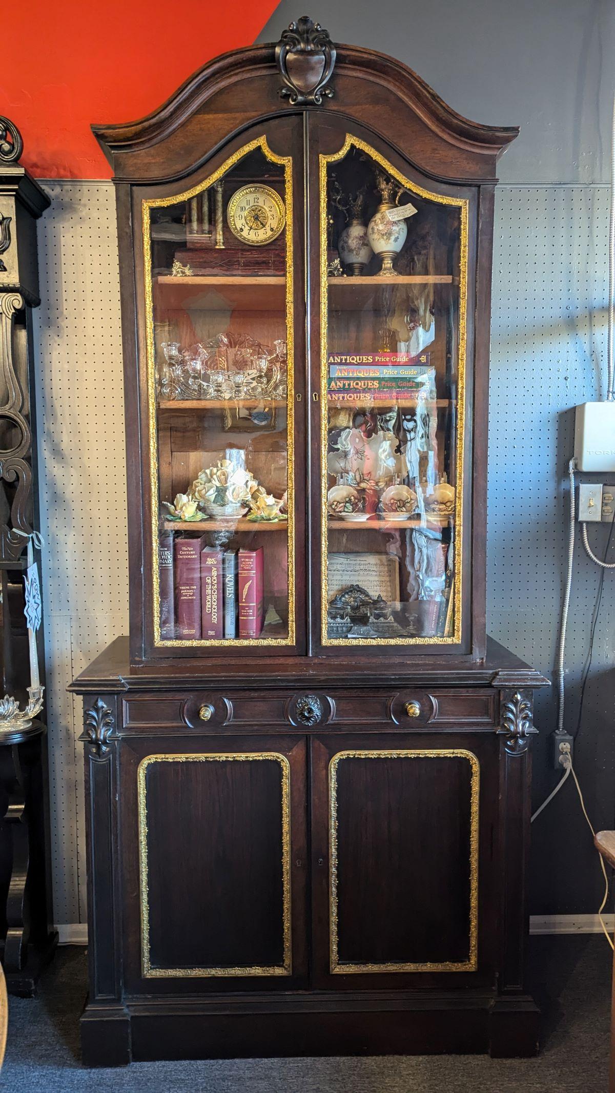 Il s'agit d'une très rare et majestueuse armoire en bois de rose avec des ferrures en laiton.  La partie inférieure comporte un tiroir complet avec des poignées sculptées au-dessus d'un meuble à deux portes avec une étagère. La partie supérieure est