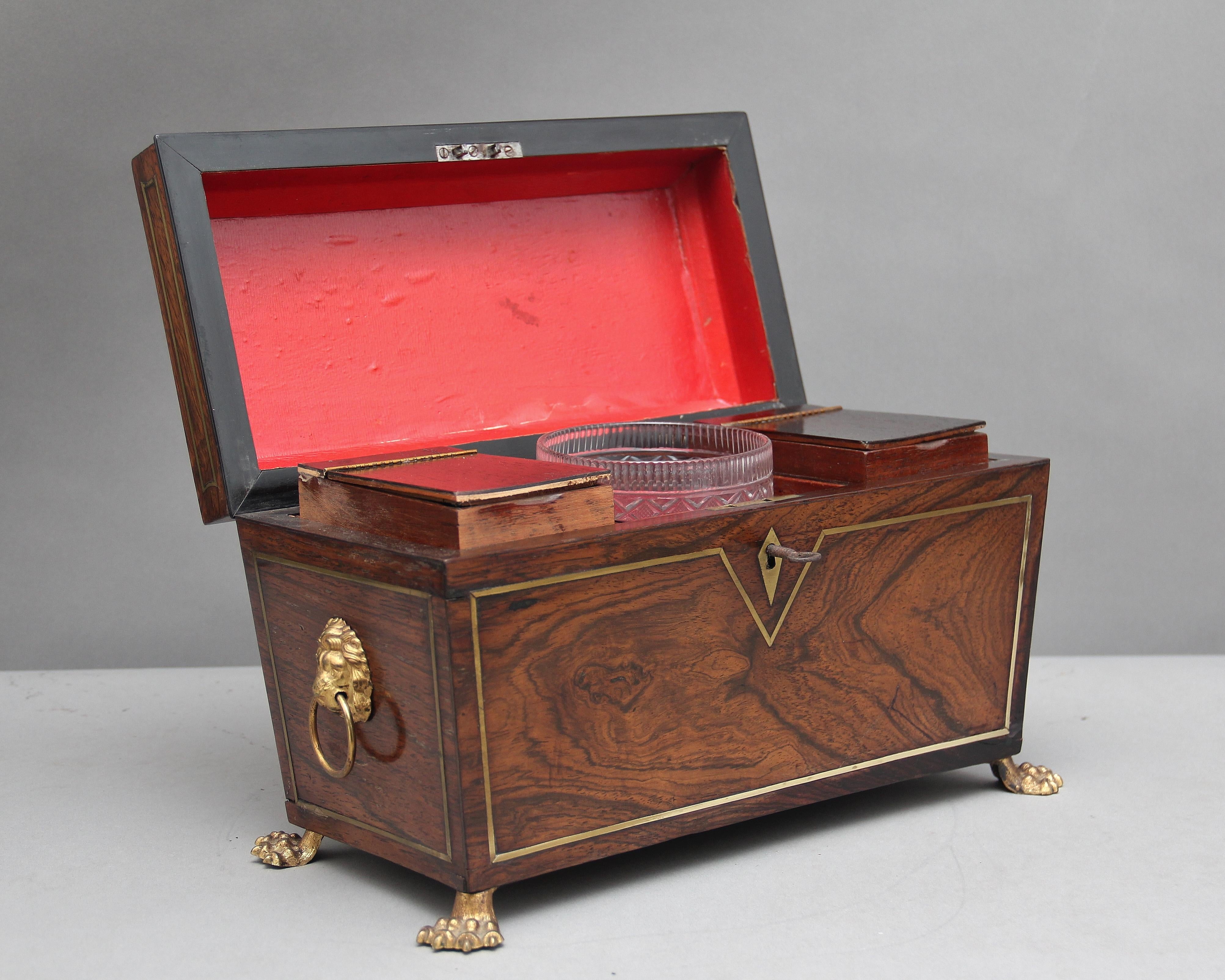 A lovely quality Regency rosewood and brass inlaid tea caddy of sarcophagus form, the hinged top opening to reveal a fitted interior consisting of centre cut glass mixing bowl flanked by twin hinged caddies, the sides of the caddy decorated with