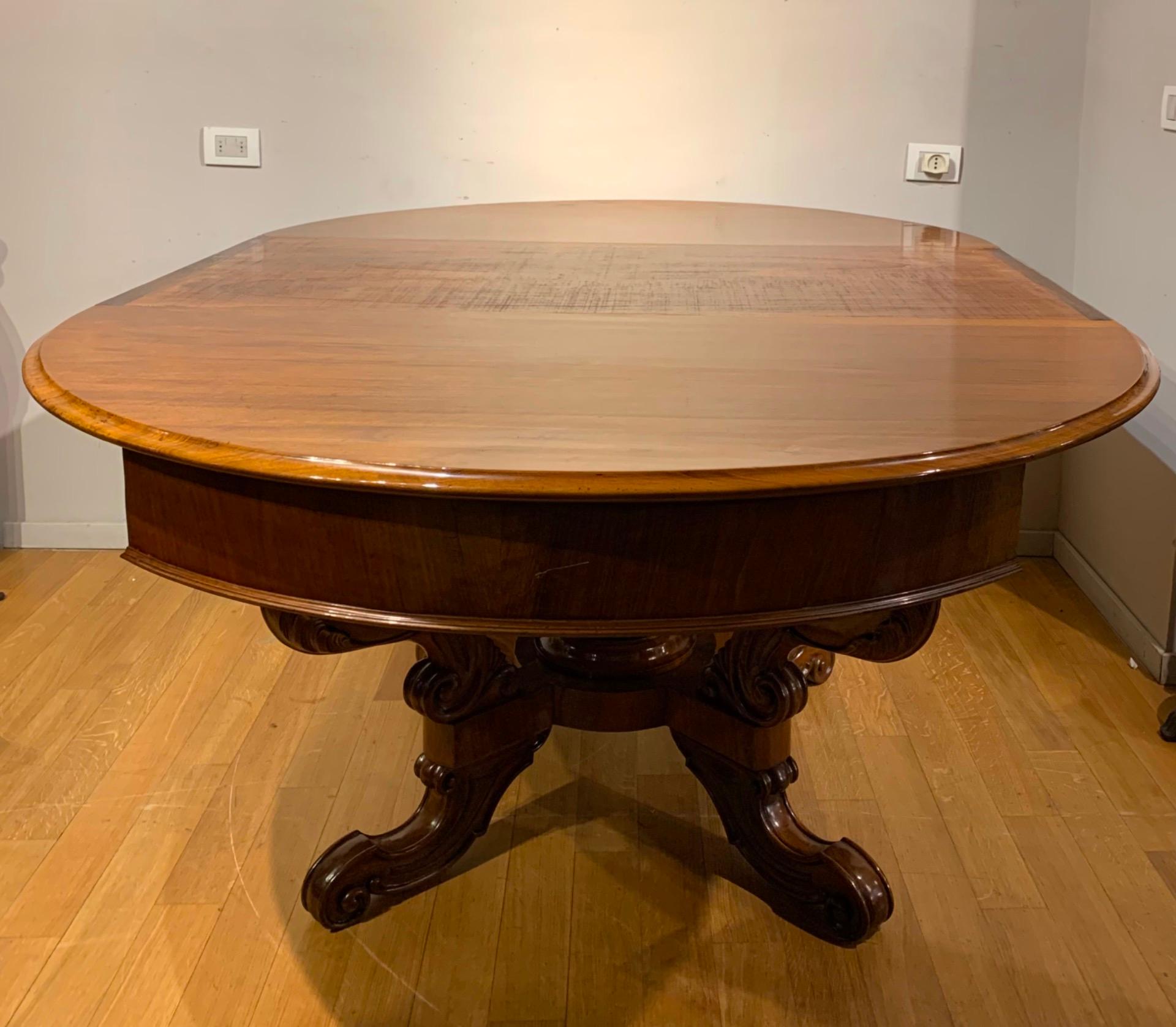 Elegant table in solid walnut with round opening top supported by four cross legs carved in the shape of a stylized cornucopia.
The top opens up to an extension of 3 m supported by 4 turned legs hidden under the top.
The table comes with a shiny