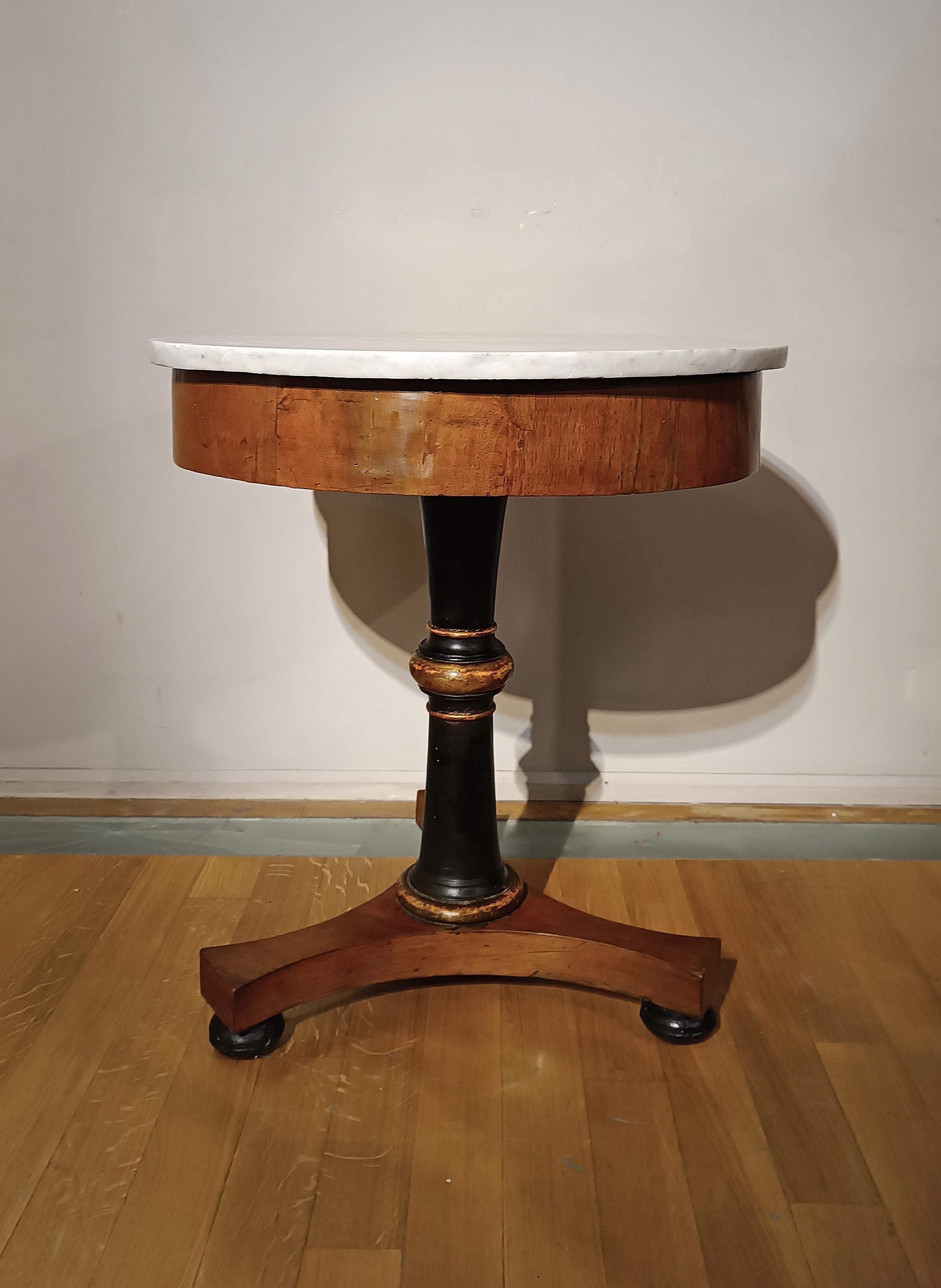 Beautiful walnut coffee table with a refined central frame in ebonized and gilded wood. The triangular-shaped base is supported by turned and ebonized pine cones, while the band has a fine walnut veneer. The white Carrara marble top completes the