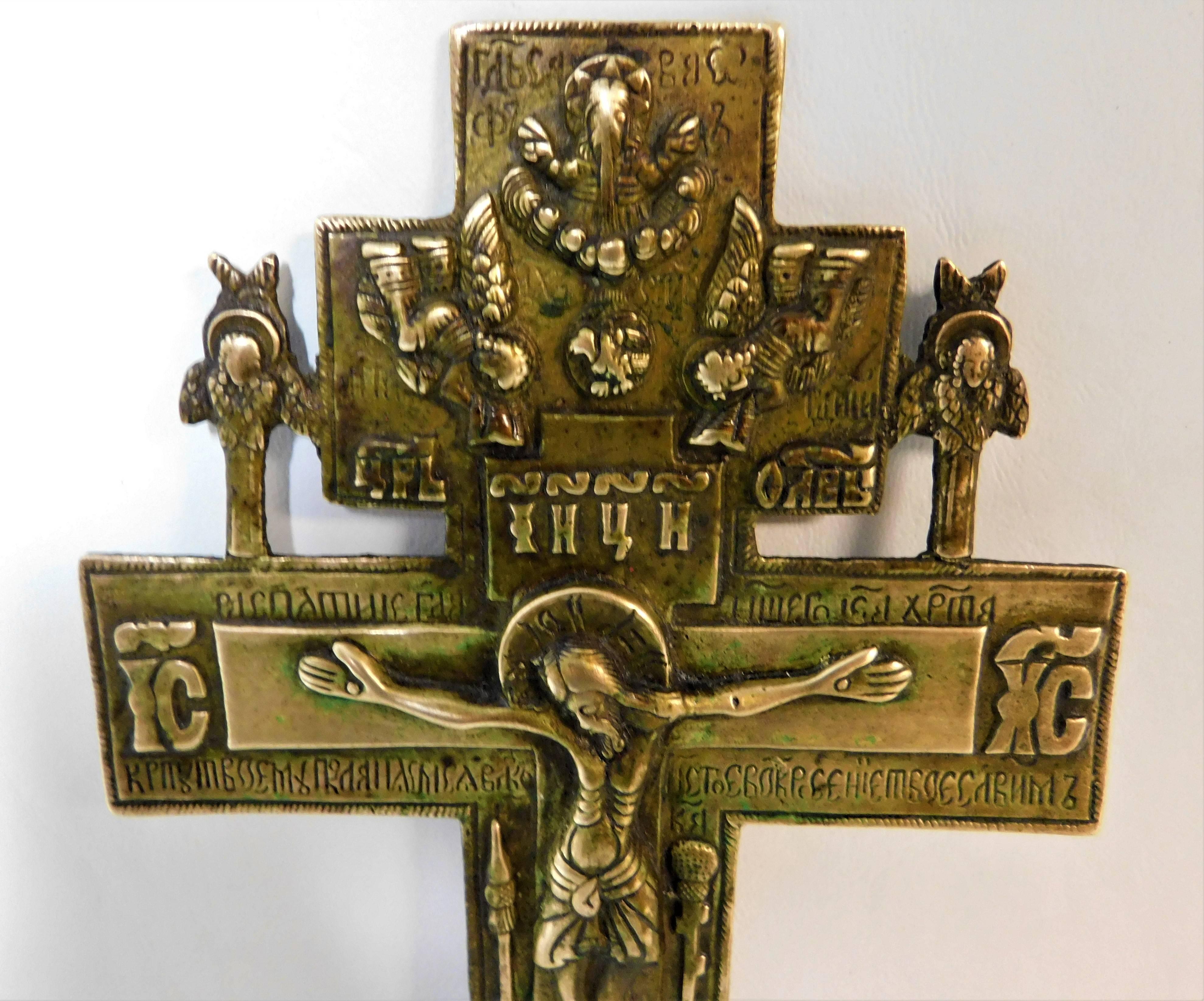 Belle croix d'icône en bronze coulé avec Jésus représenté et des anges au-dessus et un crâne enterré en dessous. Une petite croix à trois branches avec corpus est enchâssée dans la grande croix. Le revers présente des inscriptions en slavon qui