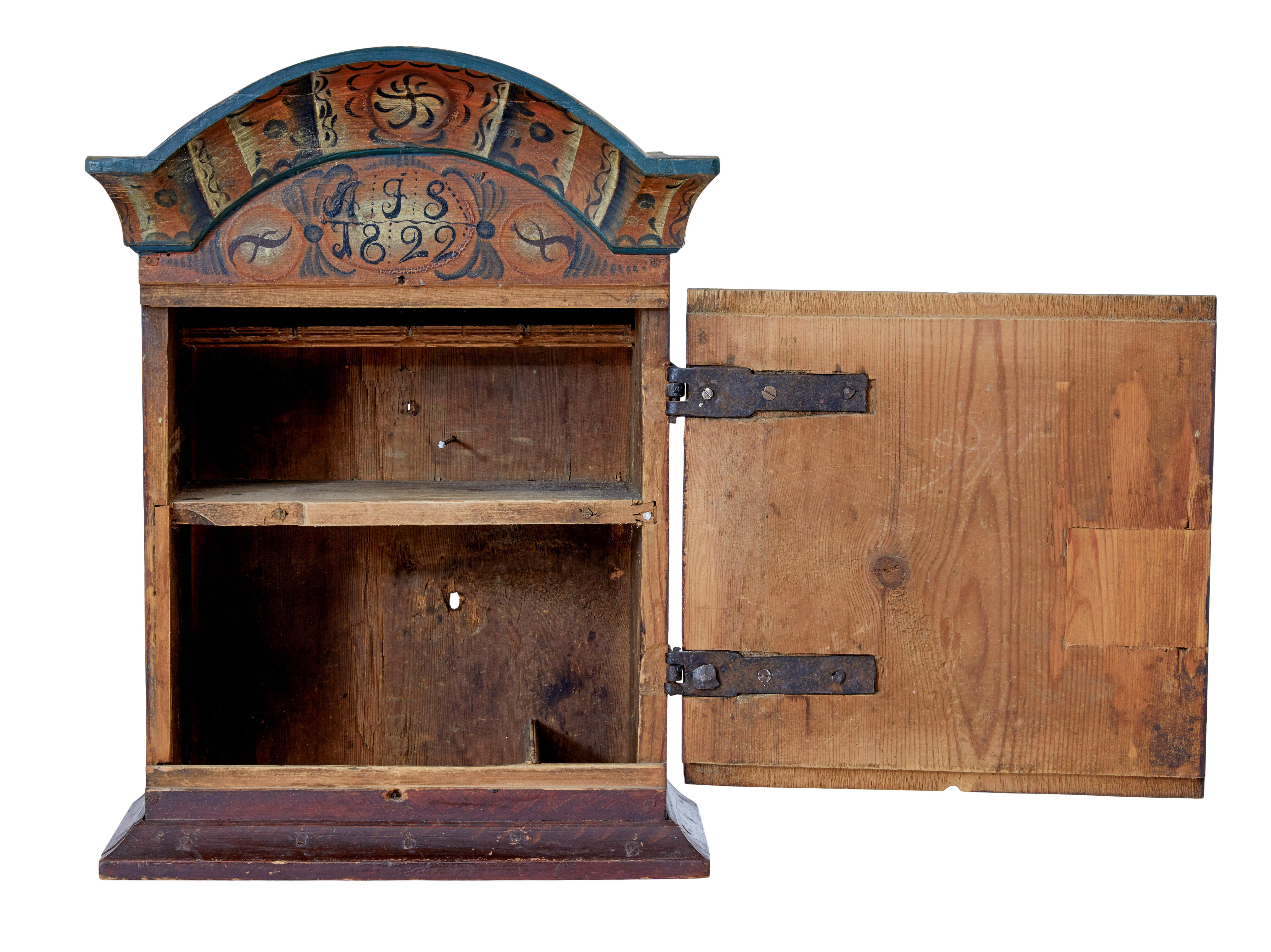 Early 19th century Swedish painted wall cupboard circa 1822.

Fine quality Dalarna region wall cupboard.  Hand painted in orange, reds and greens.  Shaped cornice below which the initials a.F.S and dated 1822.  Profusely covered in hand painted