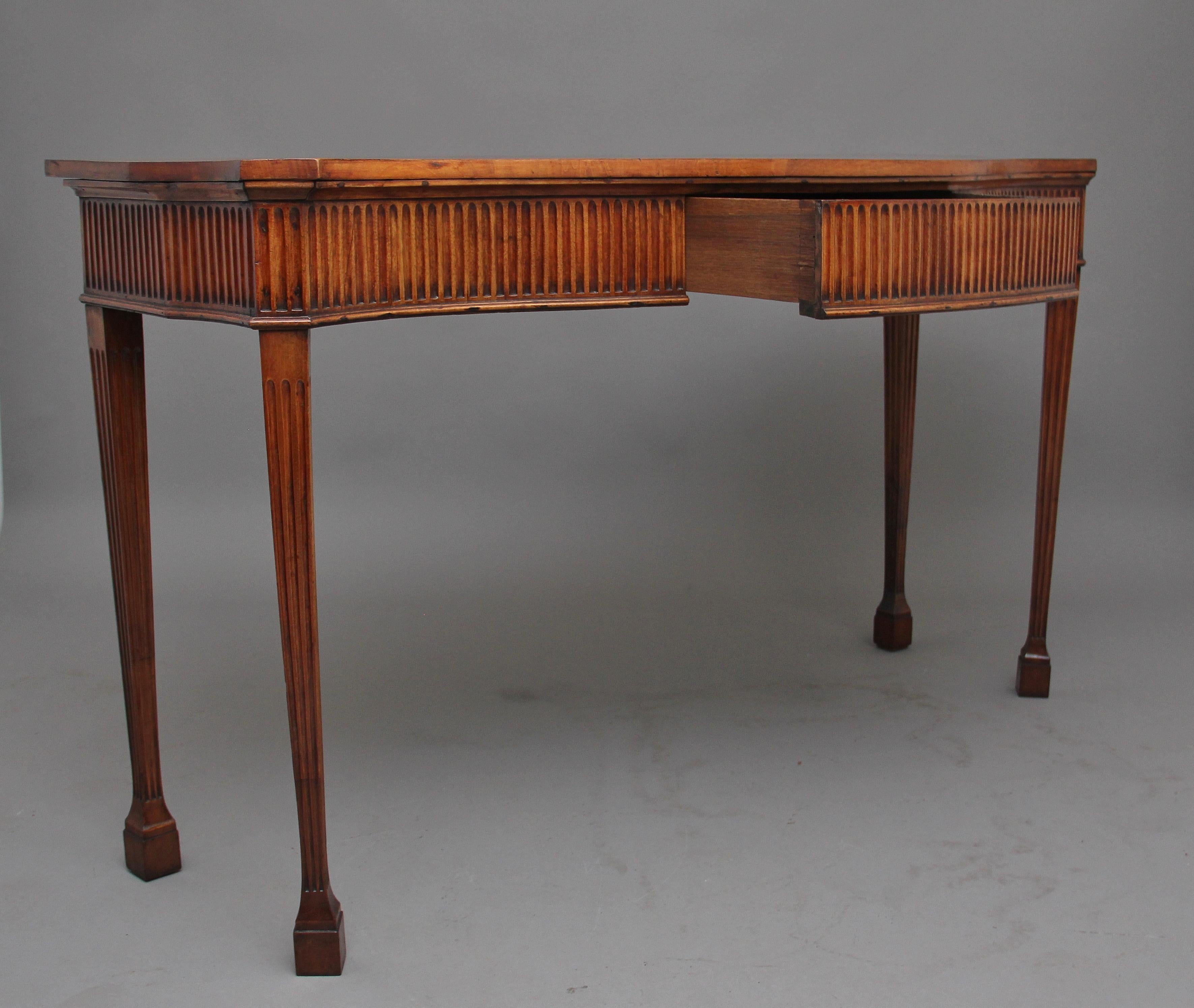 Early 19th century satinwood serpentine serving table in the Adams style, having a lovely figured and shaped top above a deep reeded frieze with a central frieze drawer, supported on four tapering and fluted legs terminating on block feet, circa