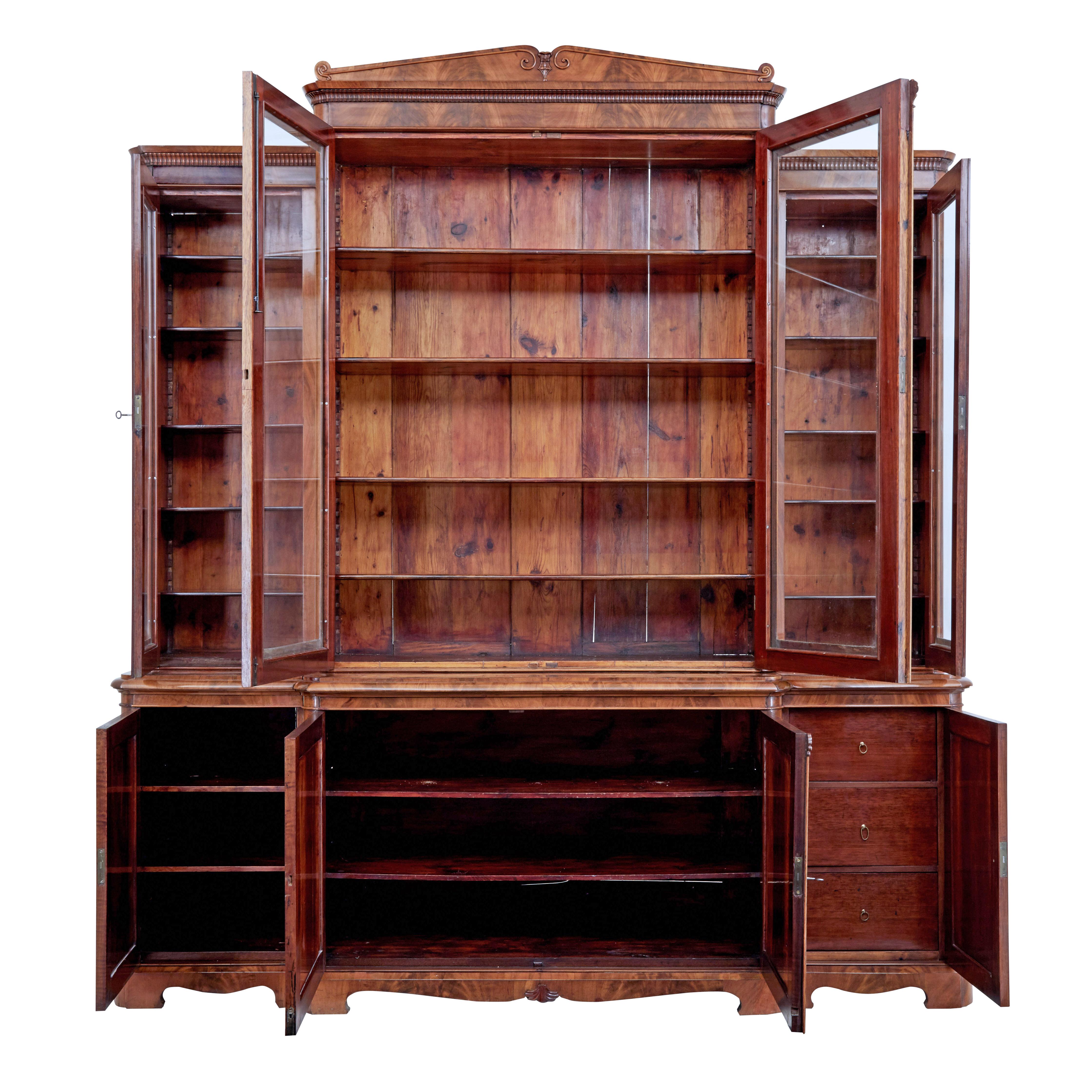 Early 19th century Scandinavian empire flame mahogany breakfront bookcase circa 1820.

Stunning bookcase of grand proportions veneered in golden flame mahogany. Bookcase comprises of 7 sections which screw together to. 3 sections to the base, 3