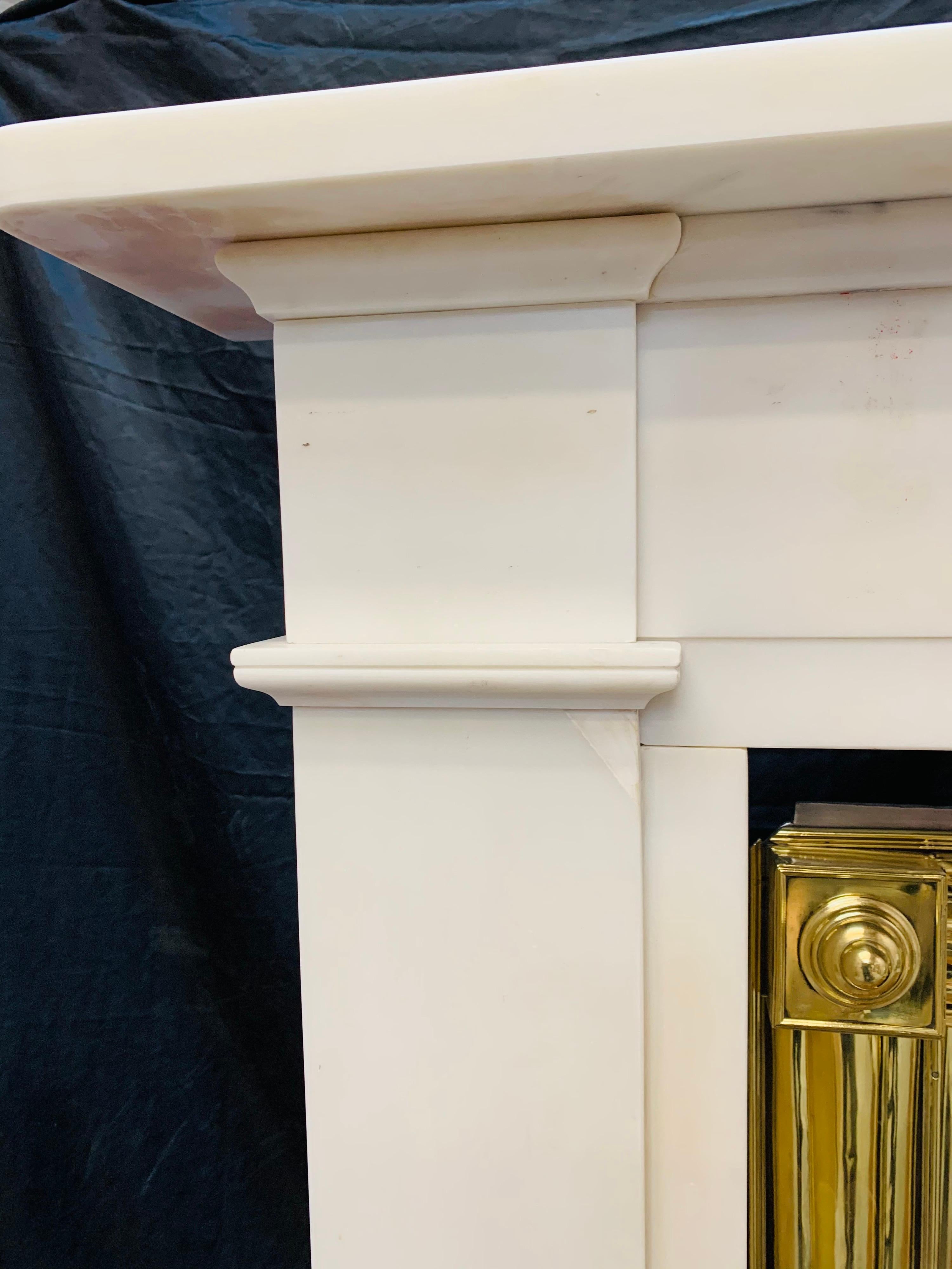 A large, rare and elegant early 19th century 1810c Scottish (Edinburgh’s New Town) Georgian Statuary marble fireplace surround. A generous square edged top shelf sits above a stepped unadorned frieze panel, flanked by protruding capitol’s with base