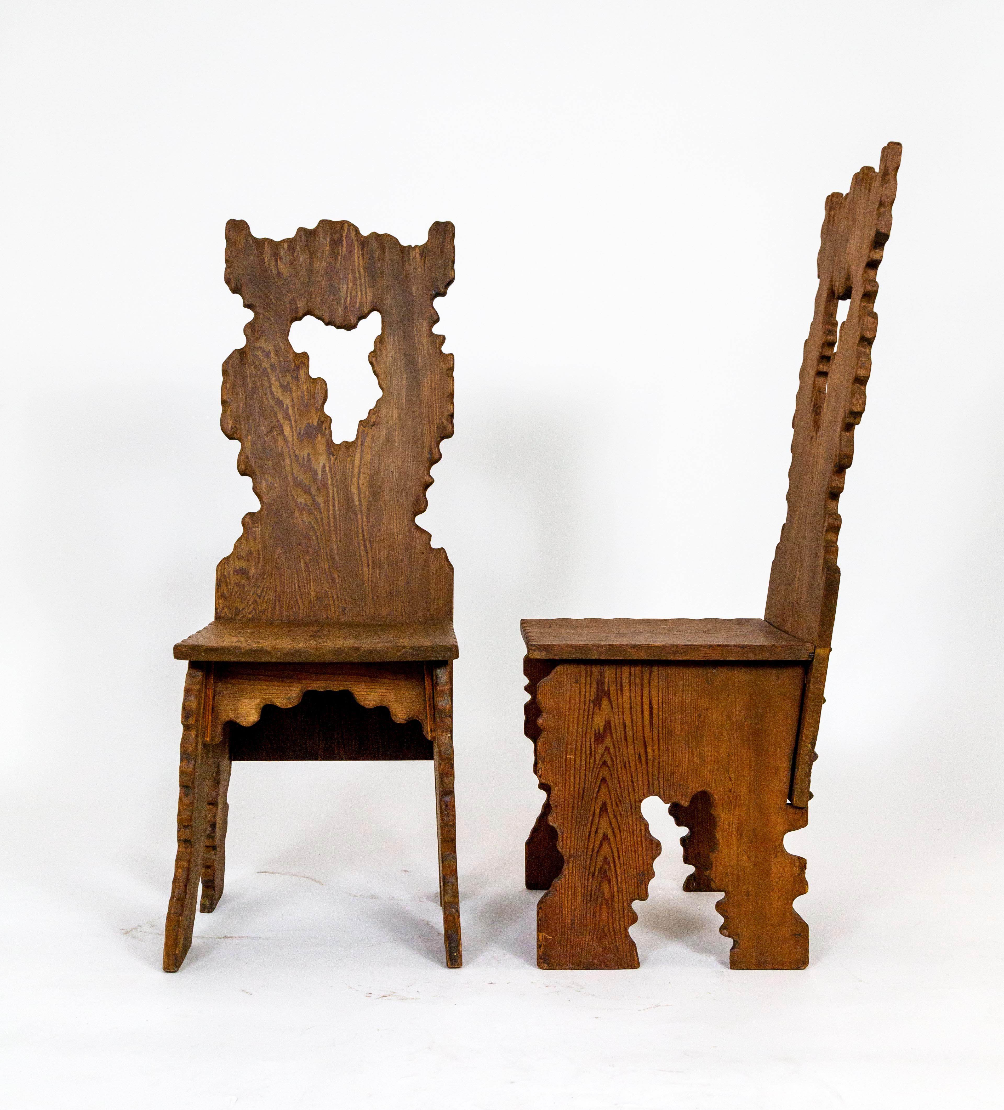 Organically shaped with a touch of whimsy this one of a kind pair of Fir chairs was handcrafted in 1912 in the Big Sur/Carmel region of Central California. The bottom of each chair is signed M. Wieland . Pyramid  shaped fastener covers finish the