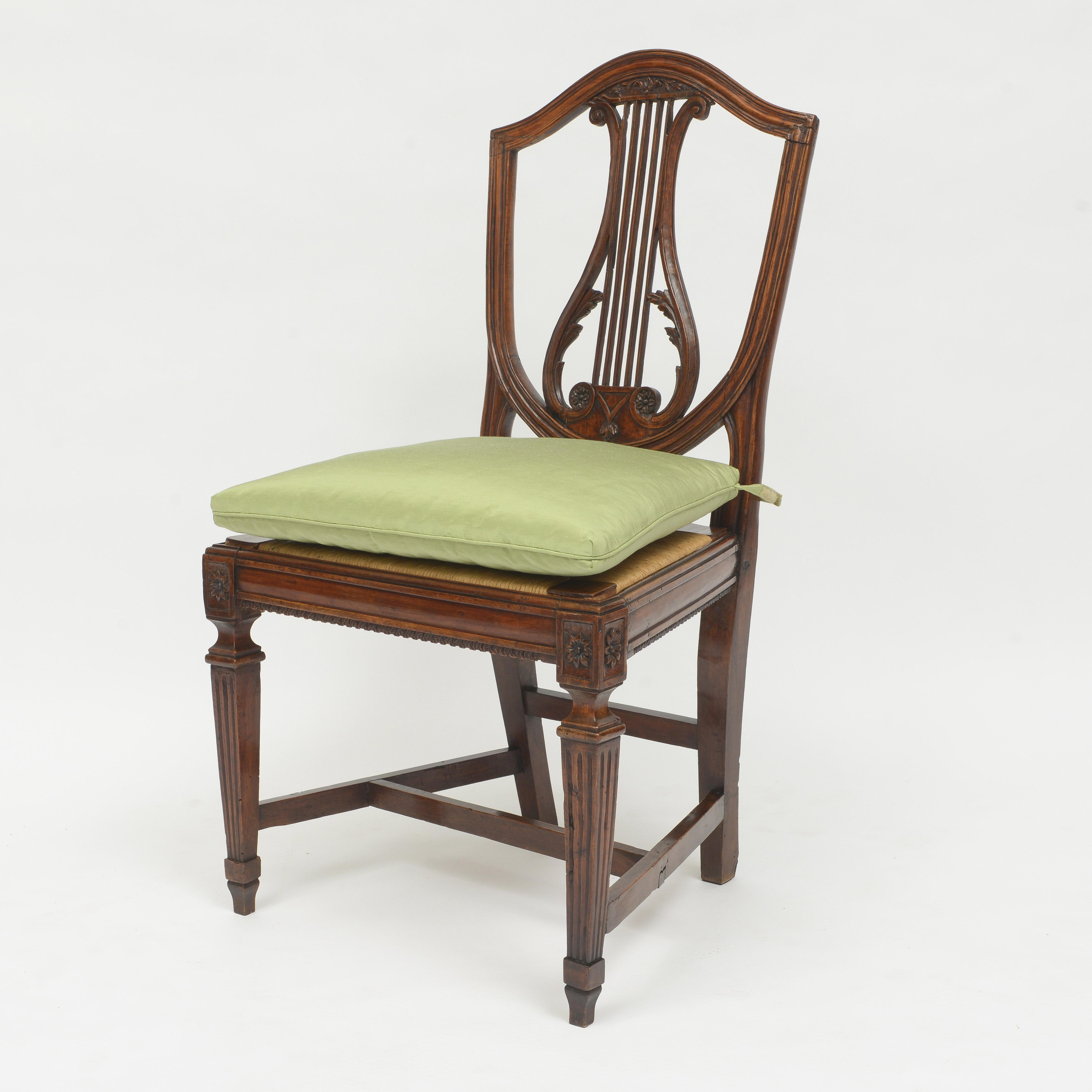 Satz von fünf italienischen Nussbaum-Esszimmerstühlen
Vergoldeter Rücken mit zentralem Lyra-Design
Binsenrohrsitze über kannelierten Beinen mit Spatenfuß
Sitzkissen mit einseitig eingefasstem, salbeifarbenem Stoff