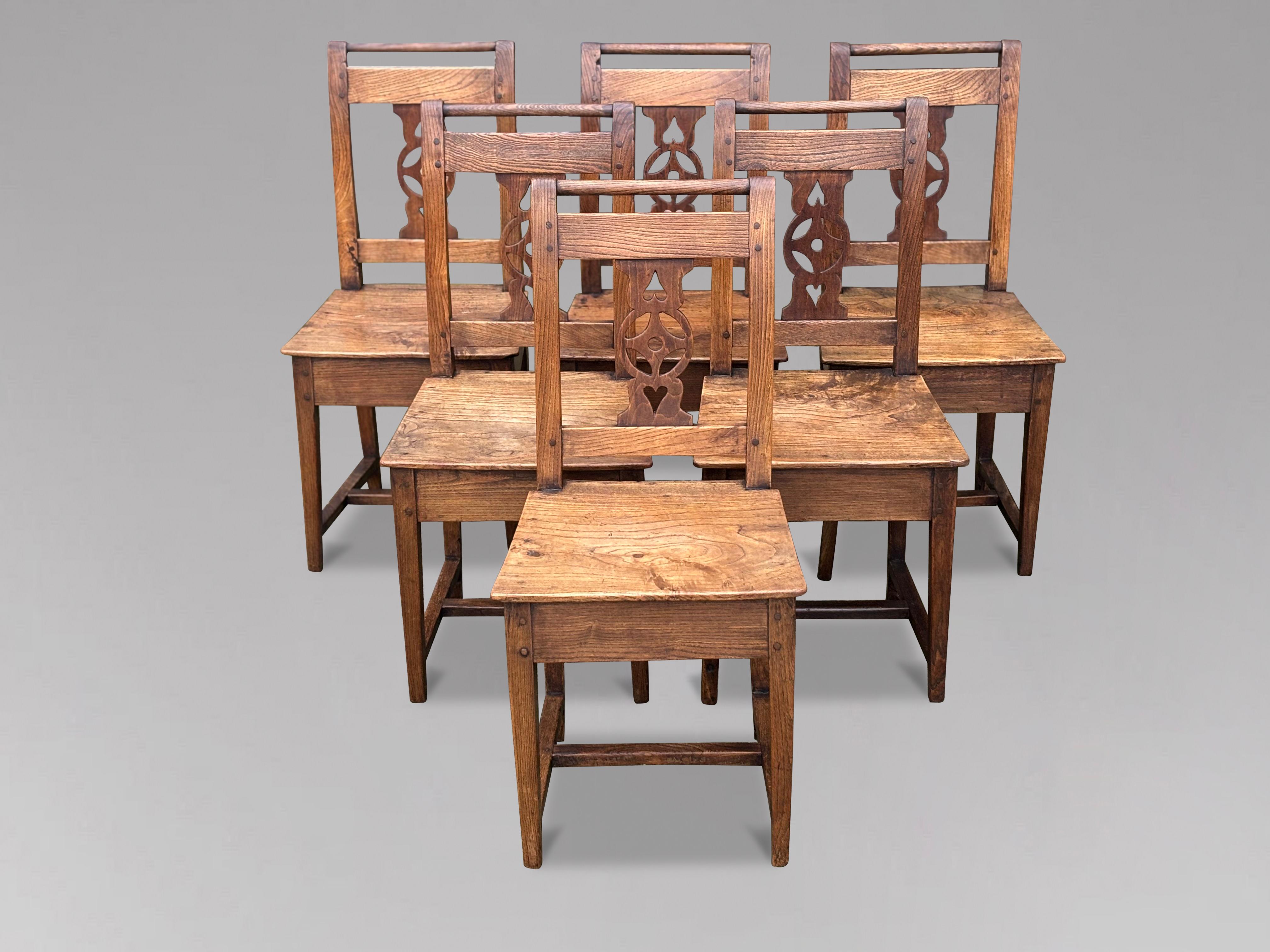 An attractive set of early 19th century, Georgian, six antique yew wood farmhouse kitchen chairs. The antique chairs each have shaped backrests with decoratively cut central splats. These antique farmhouse chairs have solid rectangular shaped seats