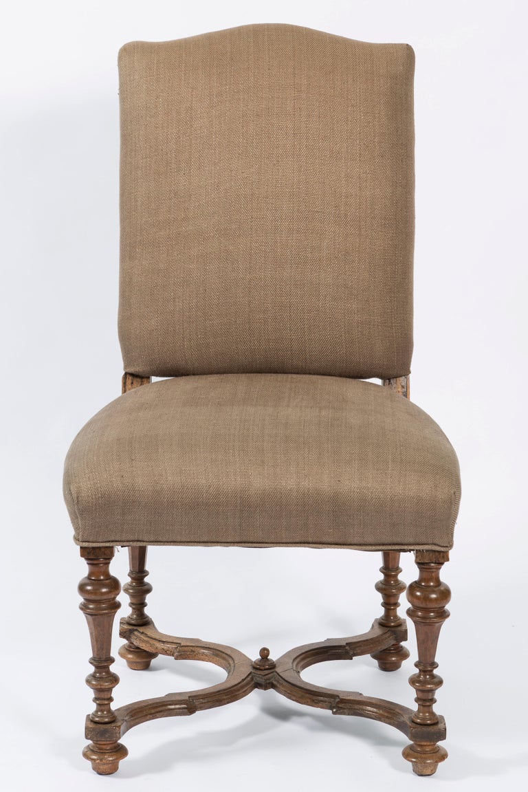 Early 19th century walnut set of four Italian side chairs. The covering is a brown linen fabric. The four legs are connected with a curved stretcher. Please note the chairs are now upholstered in the brown fabric cover in the picture.