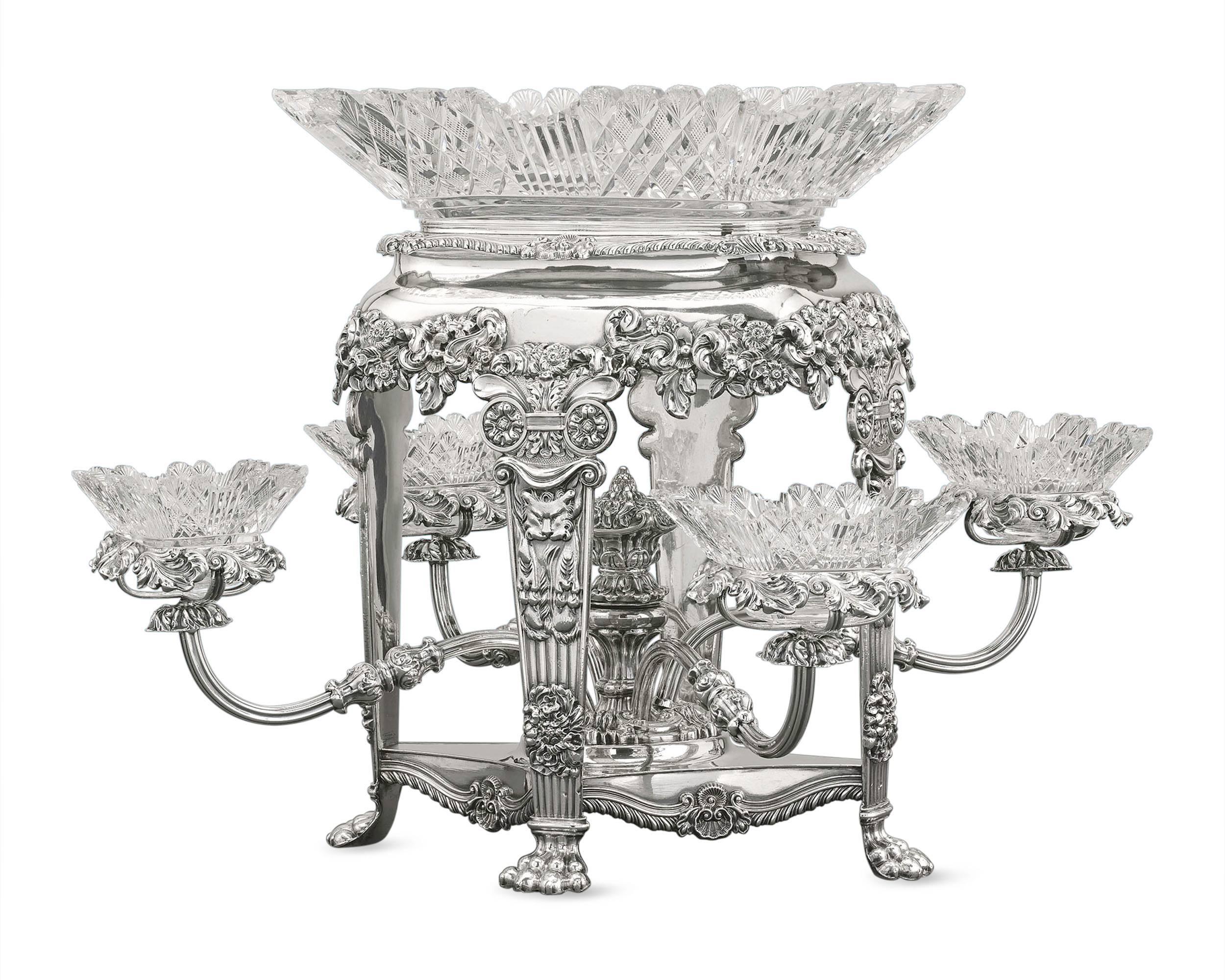 This elegant epergne is a monumental masterpiece of desirable Sheffield silver plate design. The perfect complement to any fine dining affair, the Regency period stand features a large bowl of etched glass surrounded by four circular dishes