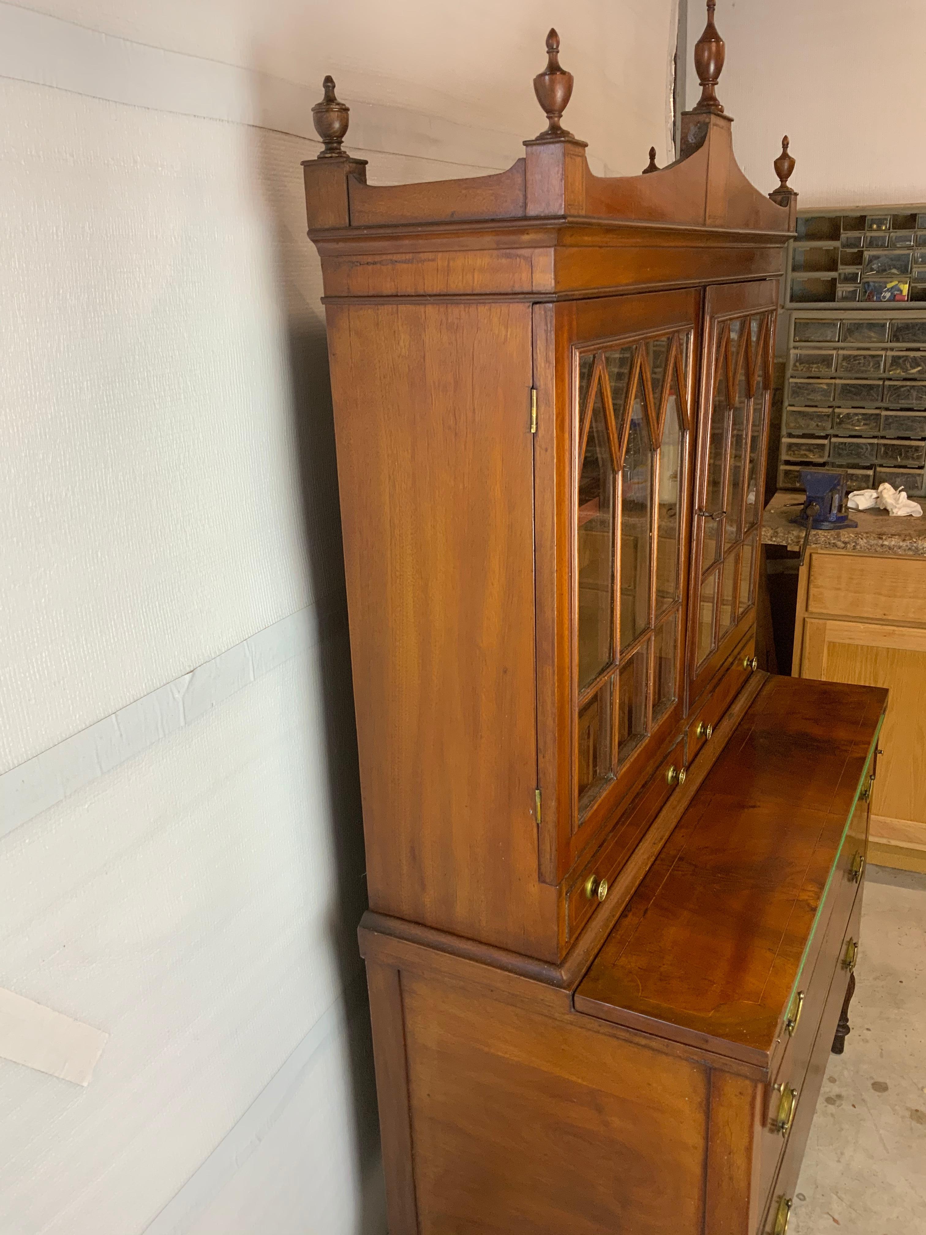  American Cherry and Mahogany two piece Sheraton Bookcase Secretary 1790-1820. This is a great smaller sized secretary with an old finish and a beautiful aged color and patina that is in very good condition. The old wavy glass on the doors are