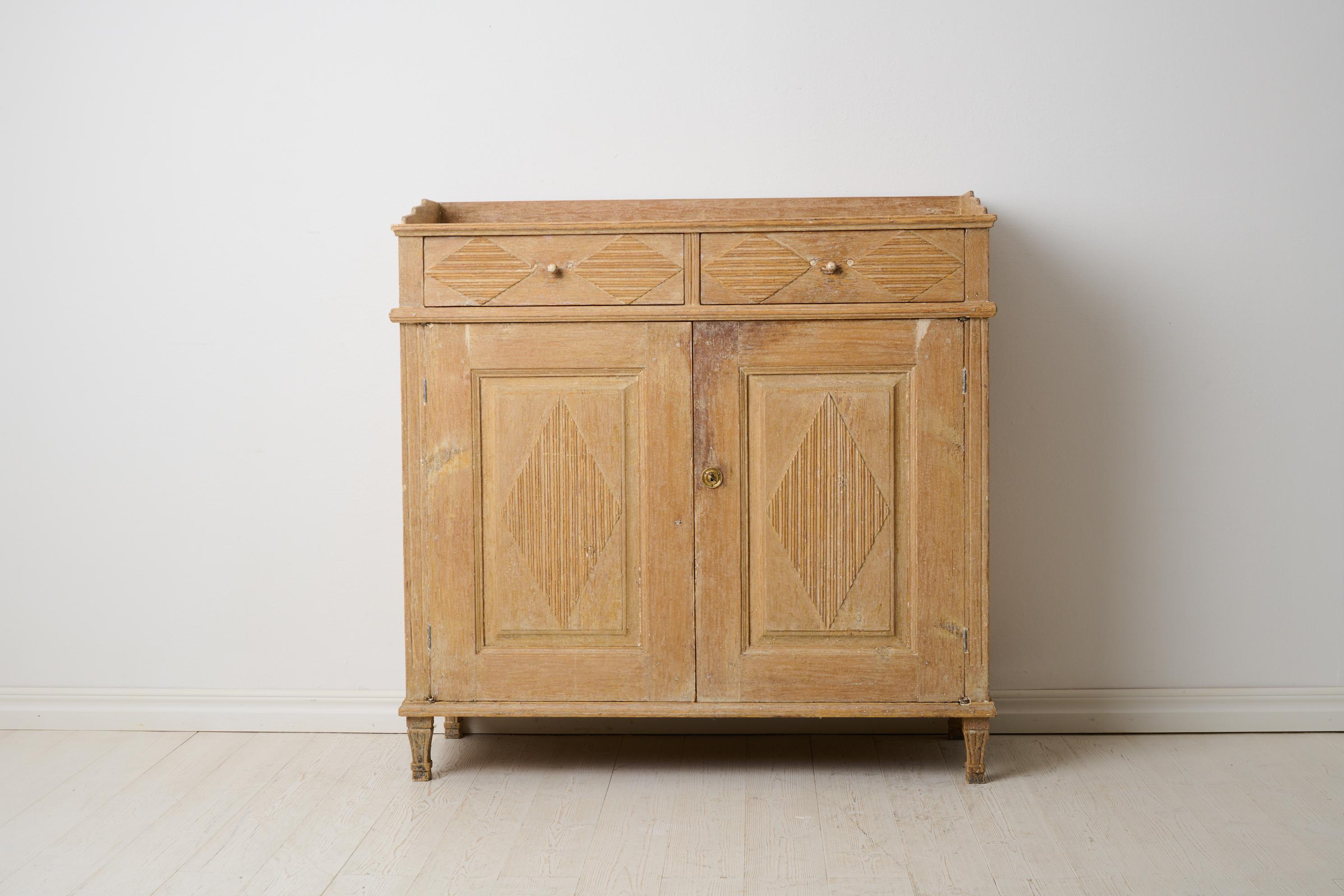 Early 19th century sideboard in gustavian style. Made in northern Sweden from solid pine around 1820. The sideboard has double doors with ribbed diamonds and classic straight corners with flutes. Rustic surface with patina and traces of the original
