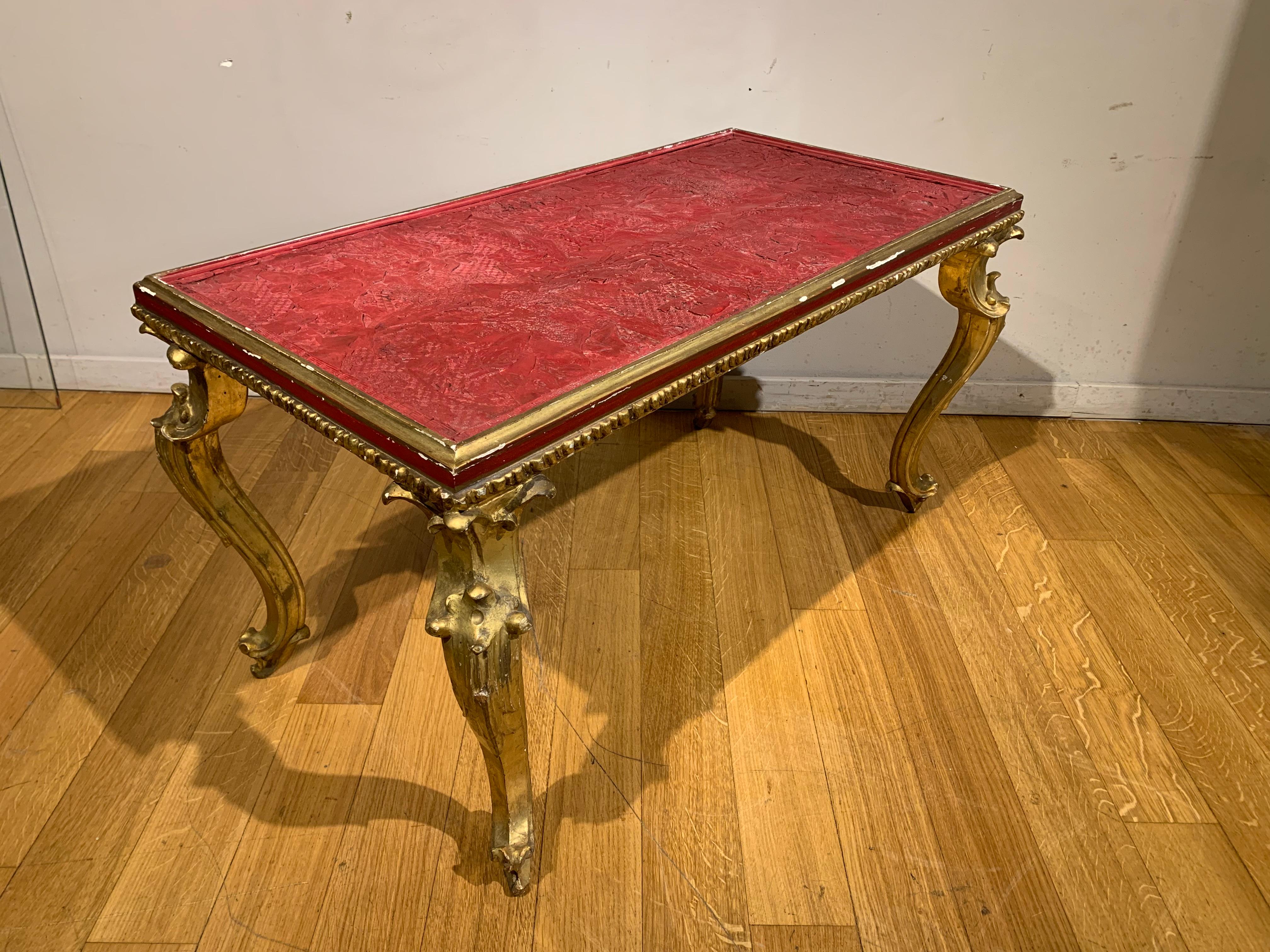 Elegant coffee table made up of four curved carved legs in the Louis XV style supporting a band in wood gilded with pure gold with a recessed top in engraved Chinese lacquer depicting scenes of imperial life.
The panel is certainly part of a door