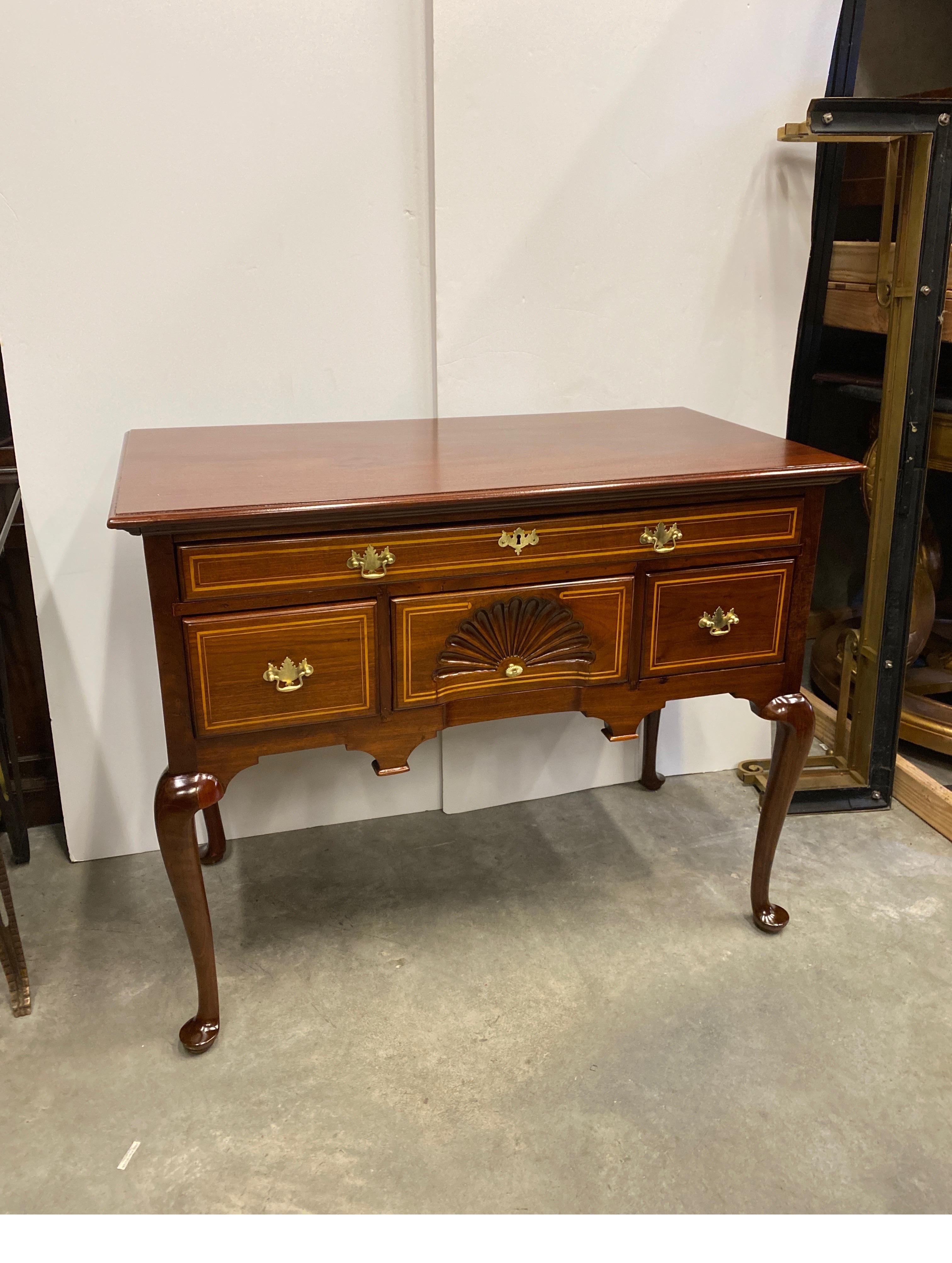 Lowboy in ciliegio massiccio realizzato a mano con intarsio a matita bionda. Il legno ricco e caldo con un intarsio di luce sui cassetti e un ventaglio intagliato a mano sul cassetto centrale. Il mobile basso ha un piano sovradimensionato, tre