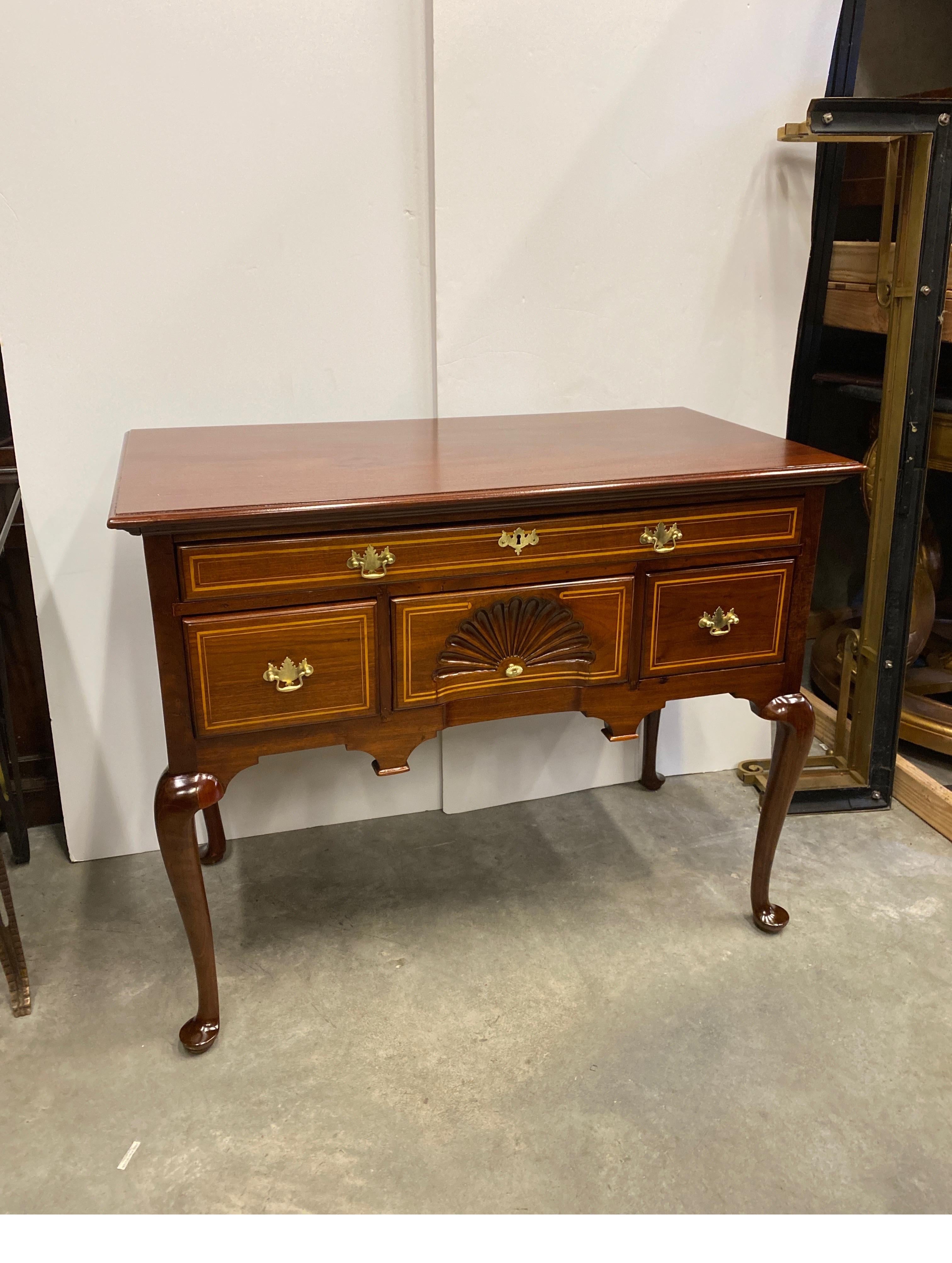 Hand made solid cherry lowboy with blonde pencil inlay. The rich warm wood with an light accent inlay on the drawers with a hand carved fan on the center drawer. The lowboy with oversized top, three drawers and hand carved curved and tapered legs