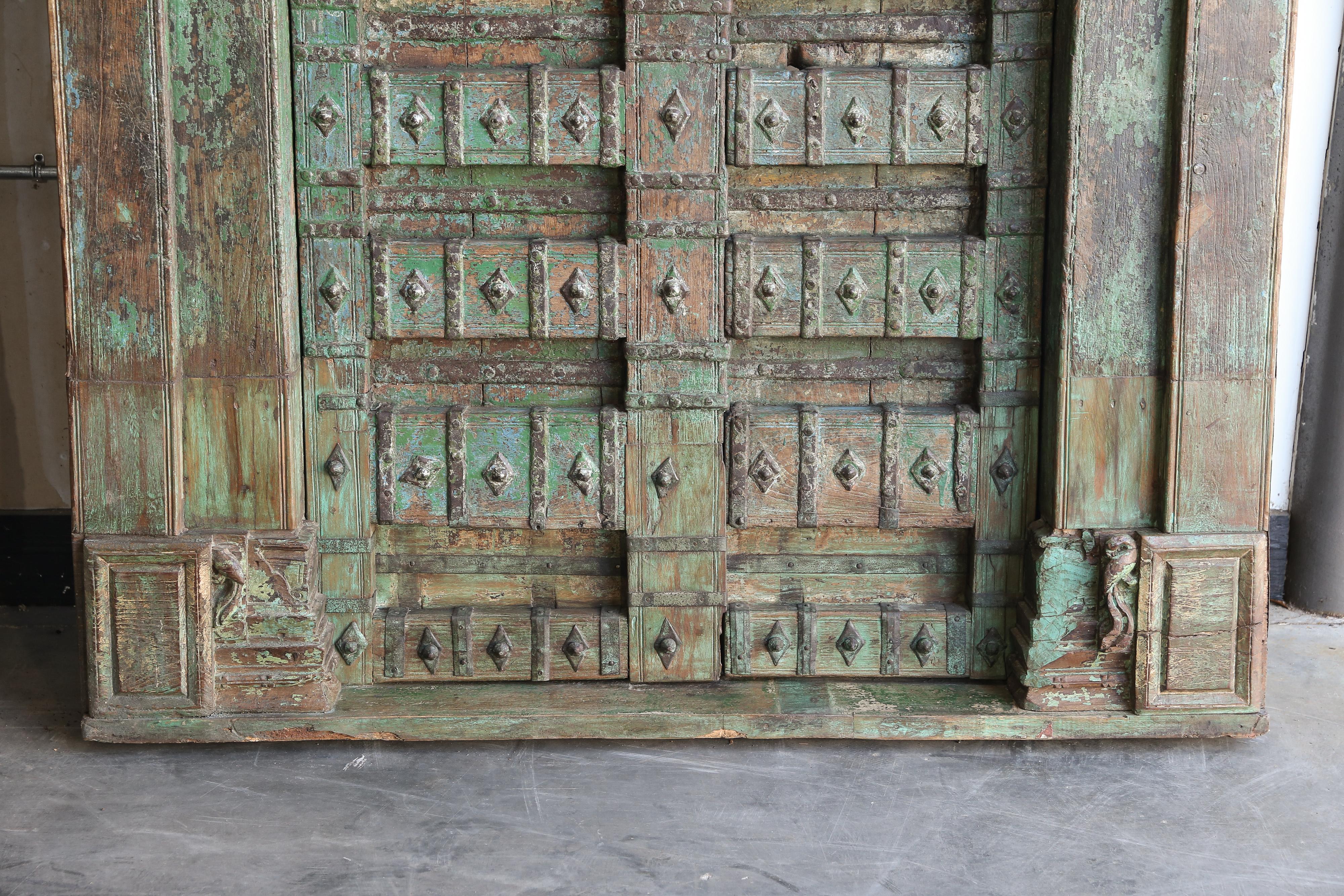 These highly fortified heavy wooden doors are handcrafted in fine teak wood. The wood is still in good condition is because for temple they use the best quality teak and other materials. From the motif of the fine carvings on the top it can be