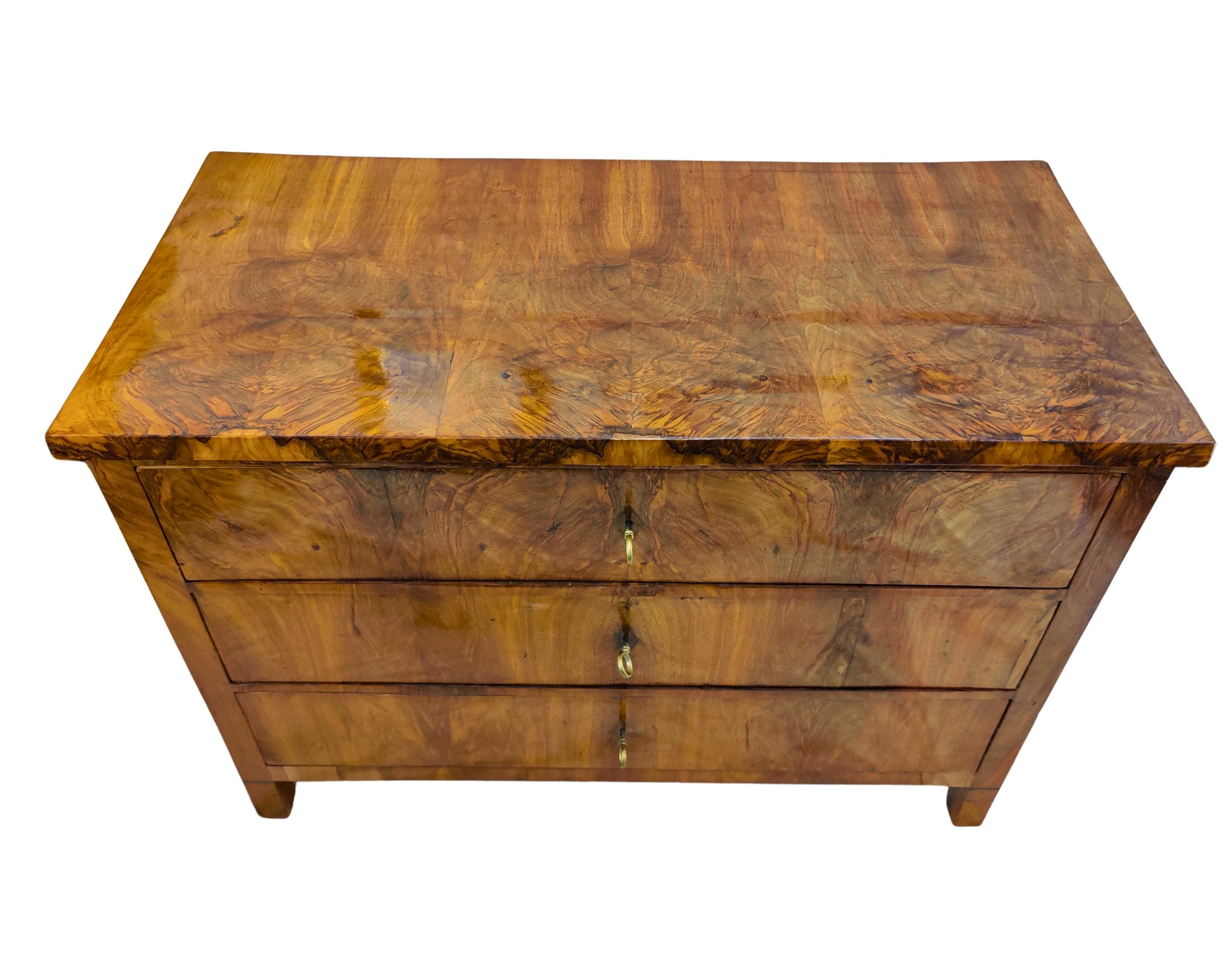 Beautiful South German Biedermeier chest of drawers, circa 1820.
The piece is crafted with outstanding walnut veneer on a solid softwood body, showcasing a wonderfully vivid and symmetrical grain pattern that highlights the natural depth of the
