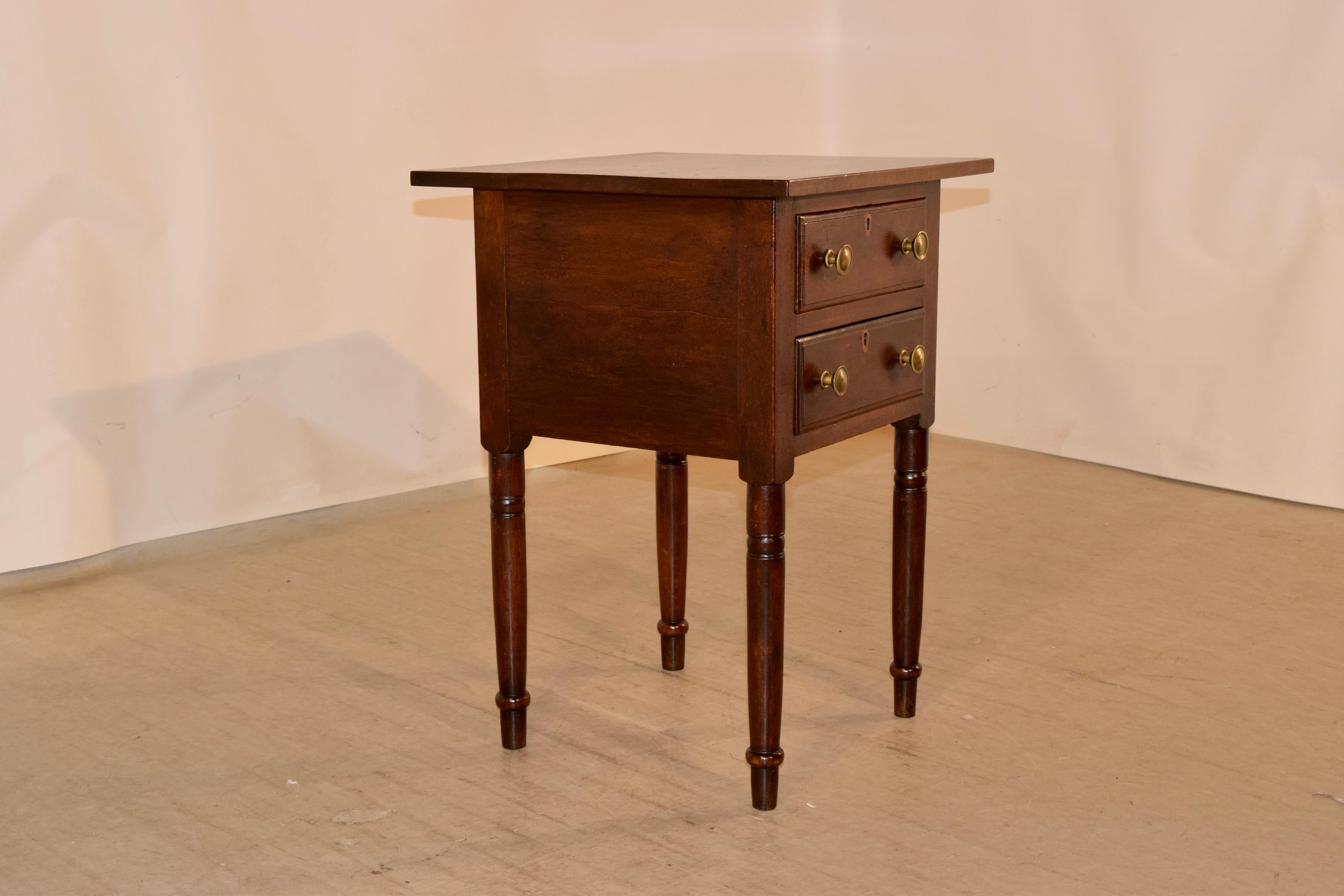 Early 19th century Southern side table made from black walnut. The table has a simple top, which is made from a single board, following down to a simple case with two drawers in the front, which have beveled edges. The table is supported on hand