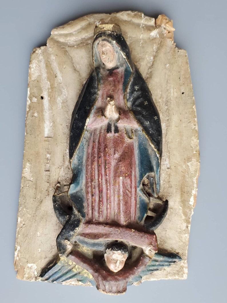 A beautiful, rustic Spanish Colonial religious relief plaque with nicely aged patina. Handcrafted by Spanish colonist settlers in Mexico in the early 1800s, with our lady of Guadalupe (Virgin Mary - Madonna) and winged cherubic angel carrying her