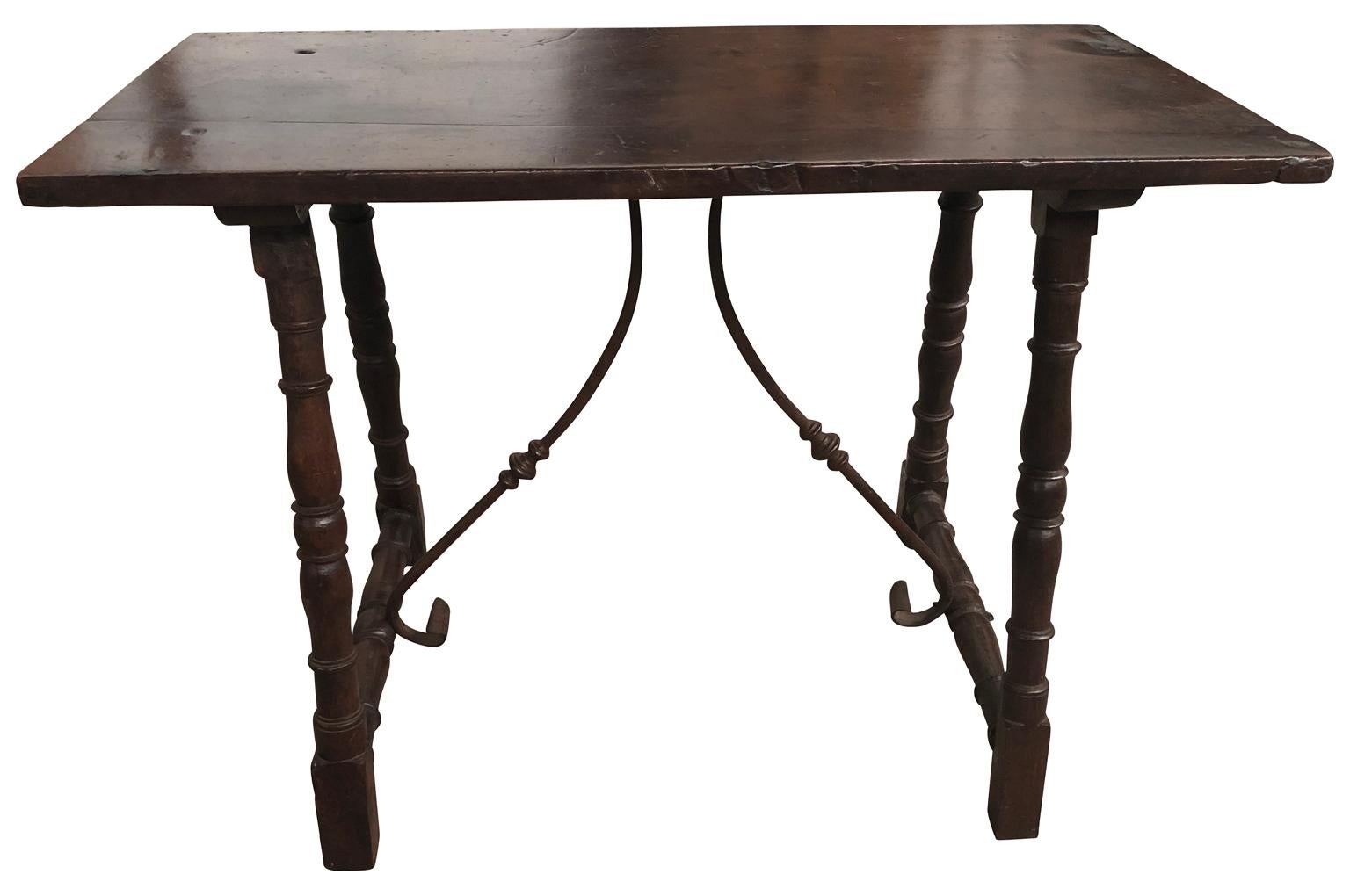 A very charming early 19th century console table from Spain. Beautifully constructed from walnut and chestnut with hand forged iron stretchers. Wonderful patina - warm and luminous.