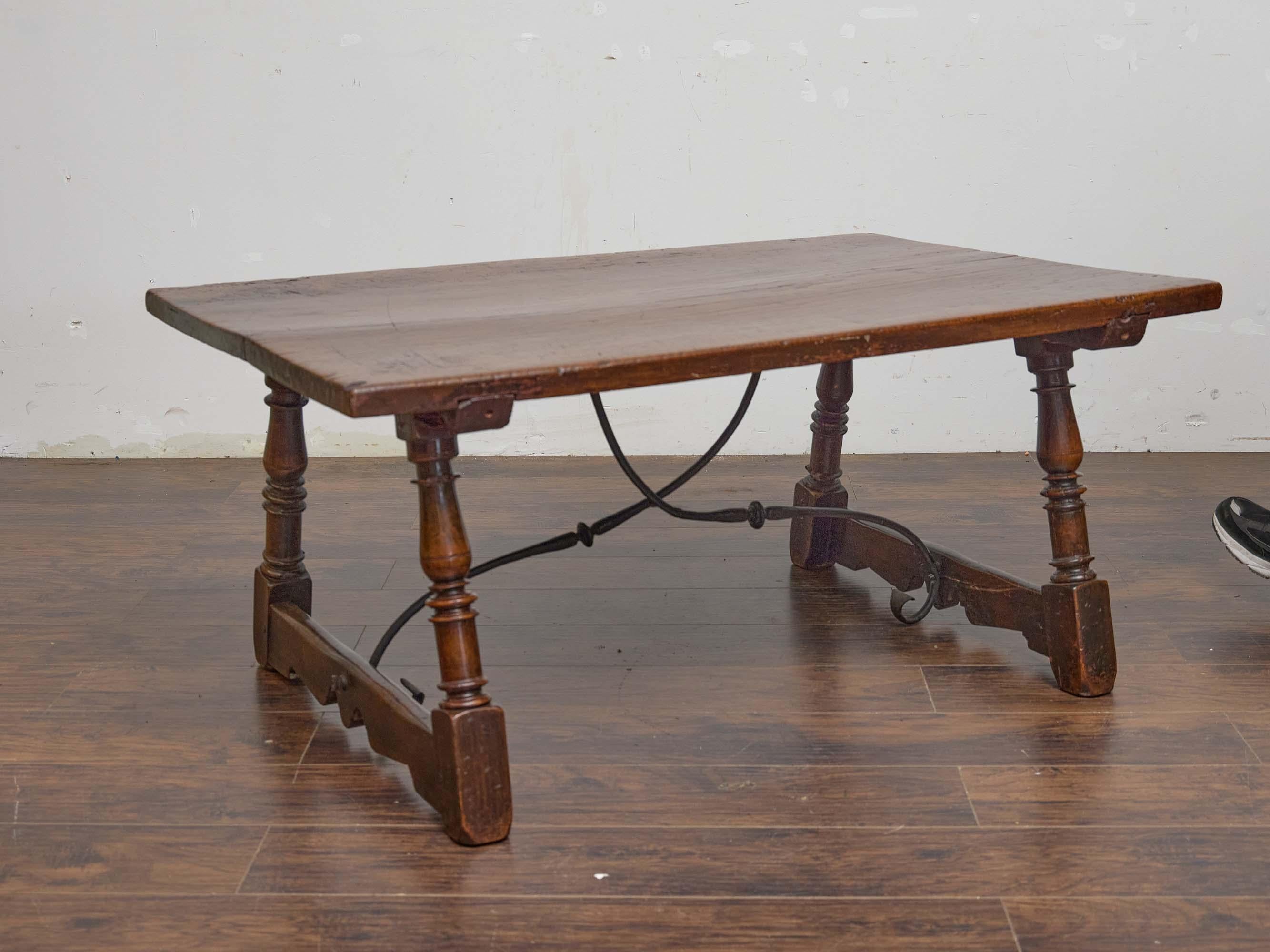 Crafted in Spain circa 1810, this low walnut coffee table brings the quiet drama of age and artisan craftsmanship to any setting. The rectangular top is hewn from thick solid walnut with a softly uneven surface that bears the honest signs of
