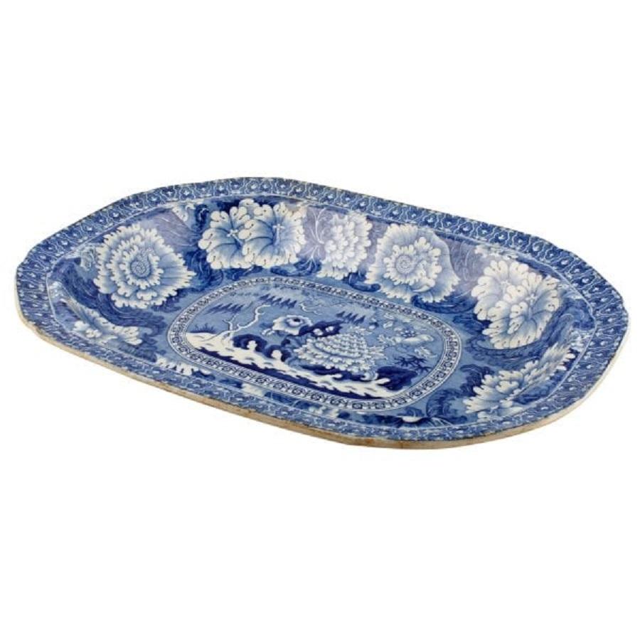 An early 19th century Staffordshire pottery blue and white deep dish.

The interior of the dish is decorated with stylised large flowers, trees and has a patterned border to the rim.

The dish is in good condition with some slight discolouration