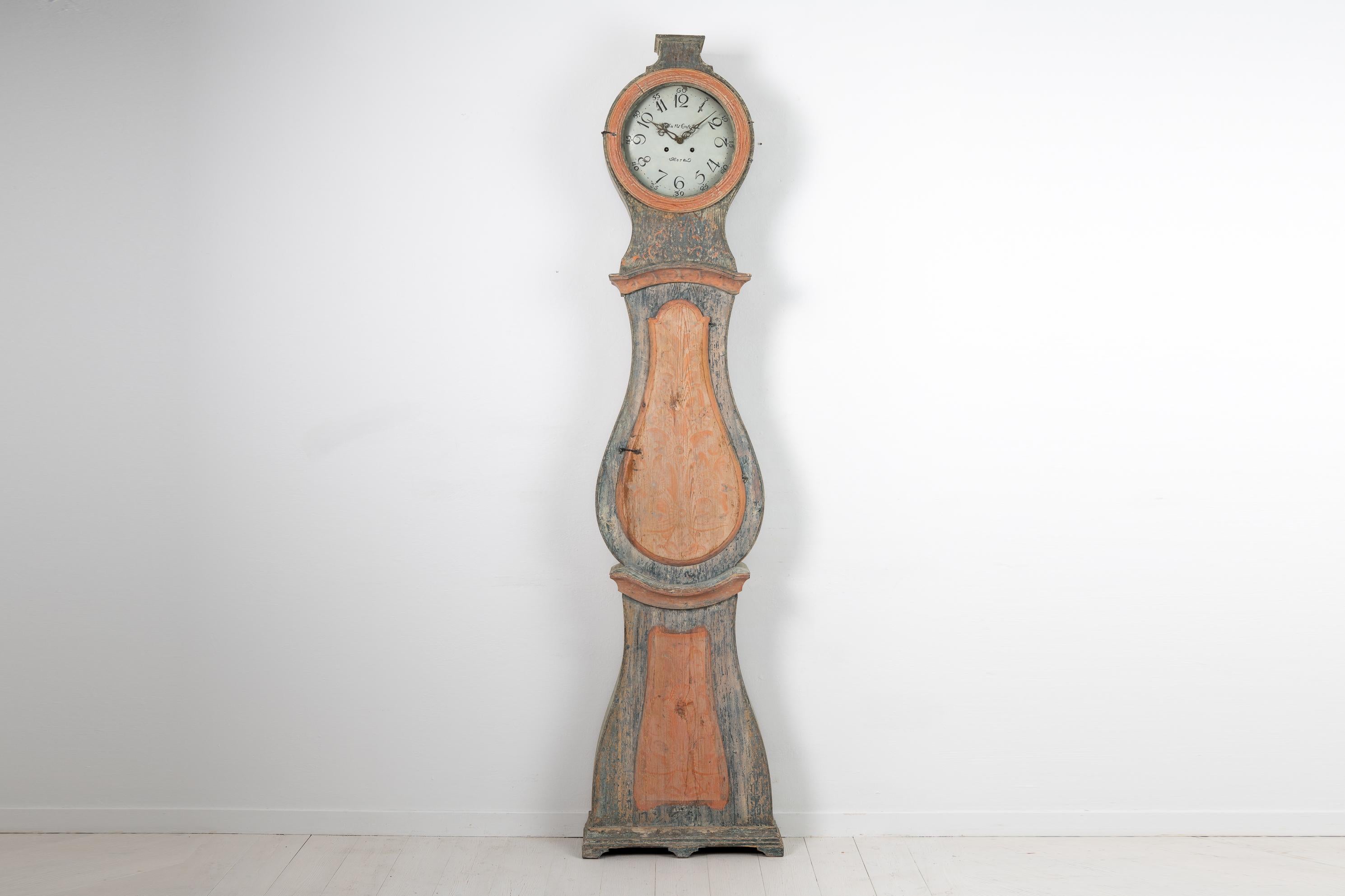 Early 1800s Swedish long case clock with blue original paint. The clock is from Sweden around 1810 to 1820 and made in pine with the classic rococo shape. The clock also has rococo hardware. Dry scraped by hand down to the original first layer of