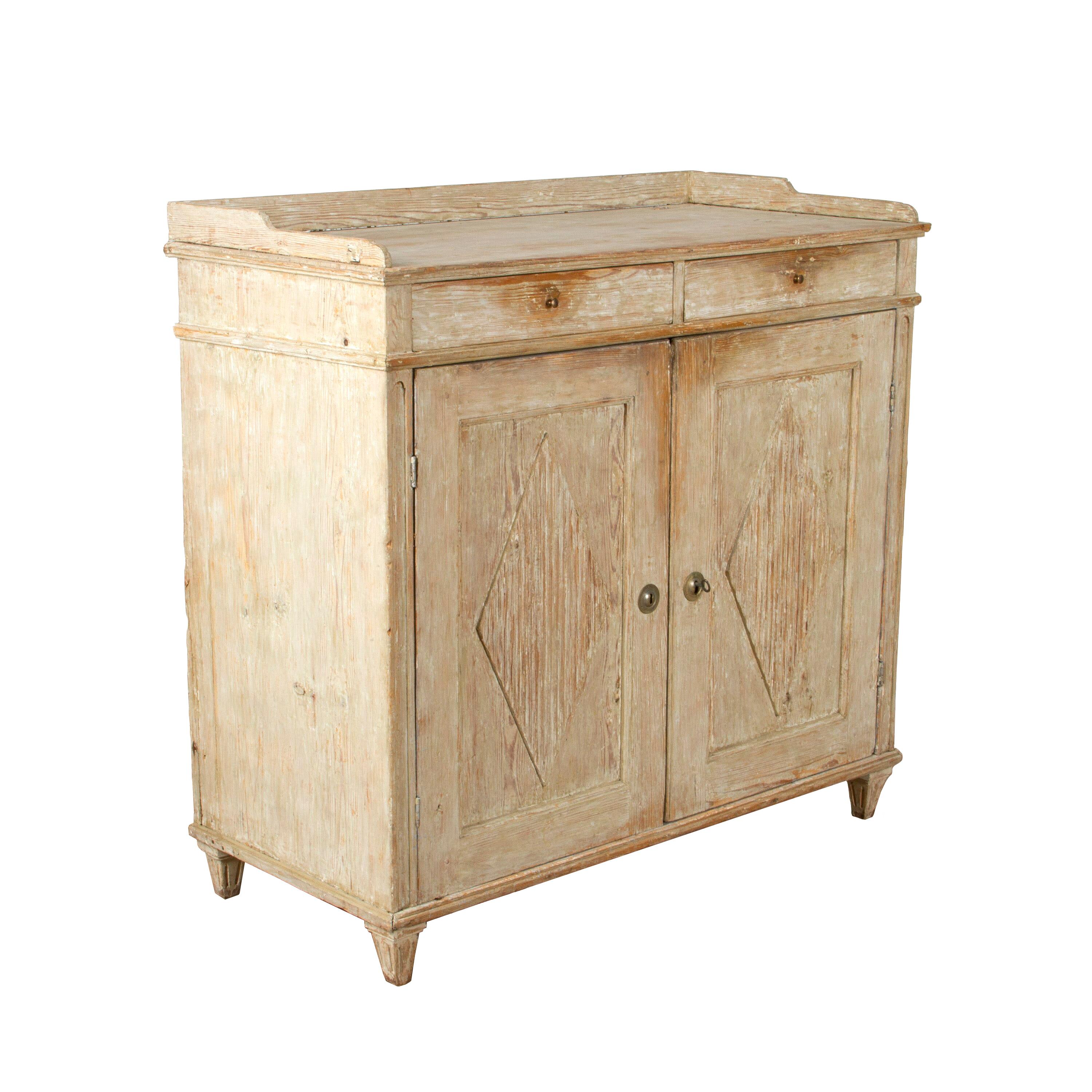This buffet has a beautiful form. It has a lovely galleried top section that sits above two panelled doors which have a decorative ribbed, diamond design carved into each side. The two panelled doors open to reveal a single shelf that is supported