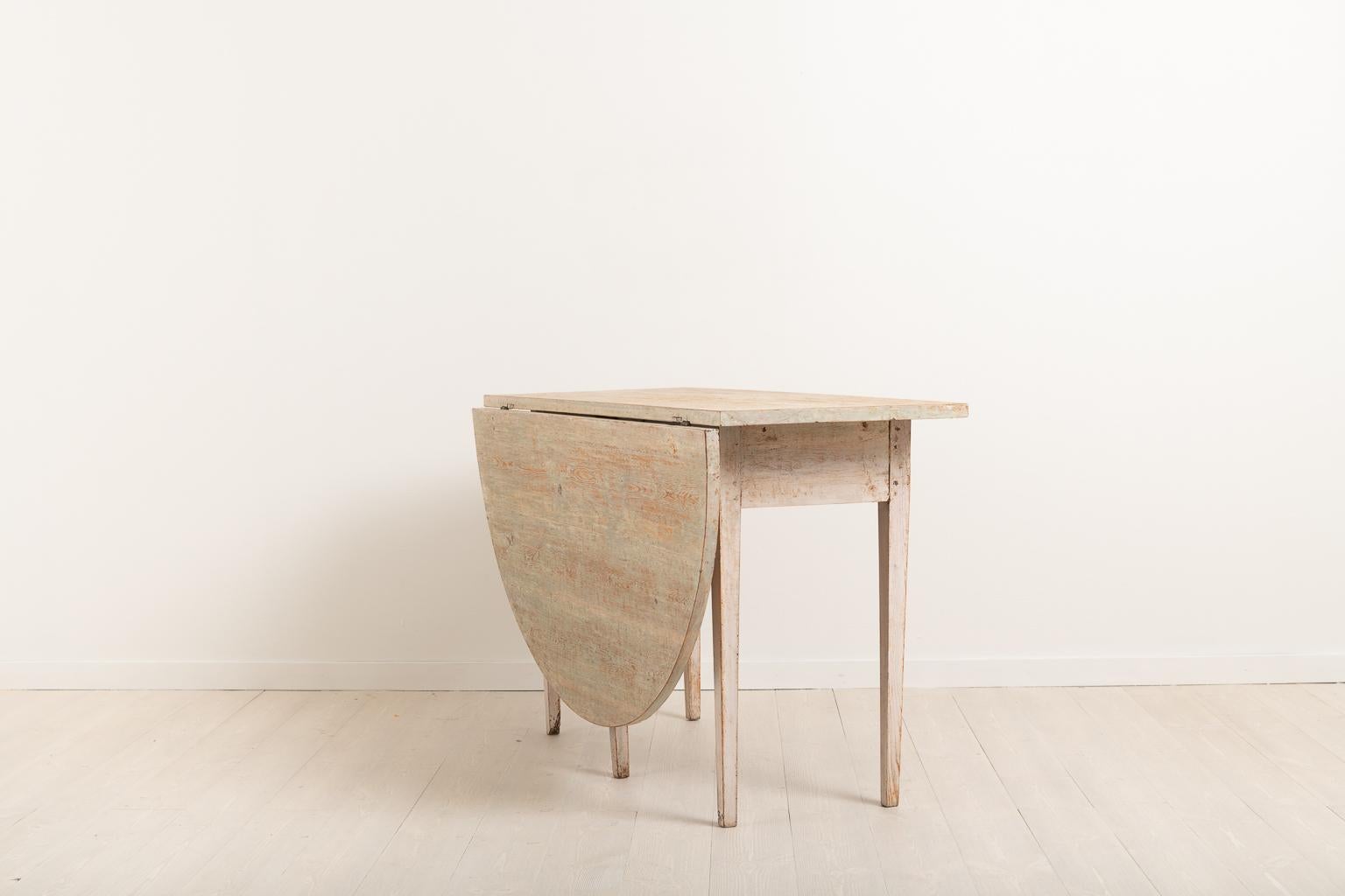 Swedish Gustavian drop-leaf table from the early 19th century. The table is dry scarped to the original paint. It is meant to stand against a wall or under a window, hence the single drop leaf. Manufactured circa 1810 in northern Sweden. The table