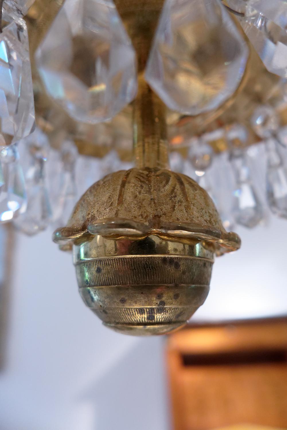 A fine early 19th century Swedish five-light crystal chandelier. The rim supporting four candle branches and a central candle nozzle above a tiered base hung with glass lustres, connected by strings of drops to a spray top, fine Stockholm quality.