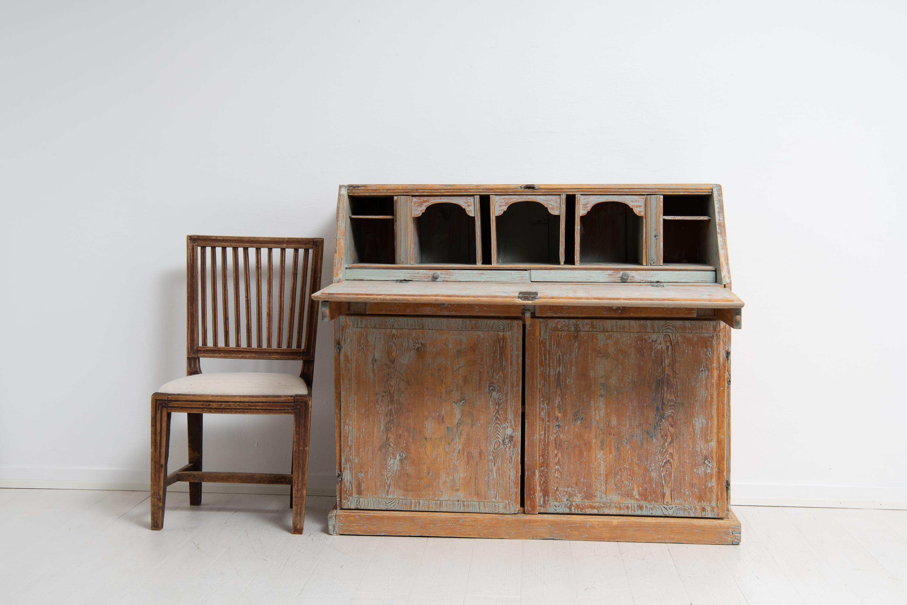 Northern Swedish folk art secretary desk from the early 19th century, 1810 to 1820. The secretary is a genuine Swedish country house furniture in pine. The surface is very distressed and the wood and its structure shines trough the paint. The