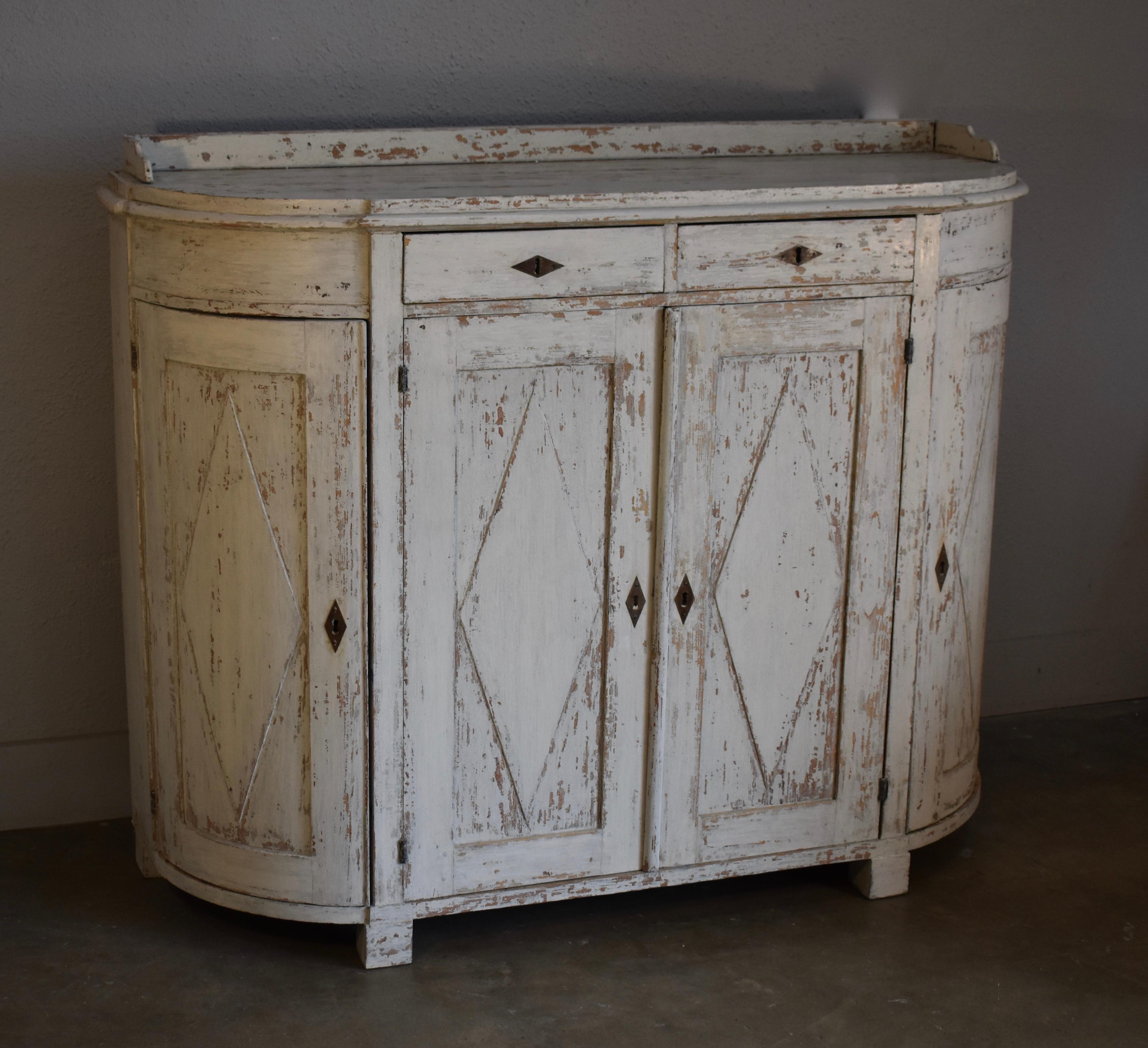 Early 19th century Swedish Gustavian demilune painted four door cupboard. All original with lovely diamond carved paneled doors and three quarter gallery top. Hinges and locks all handmade.