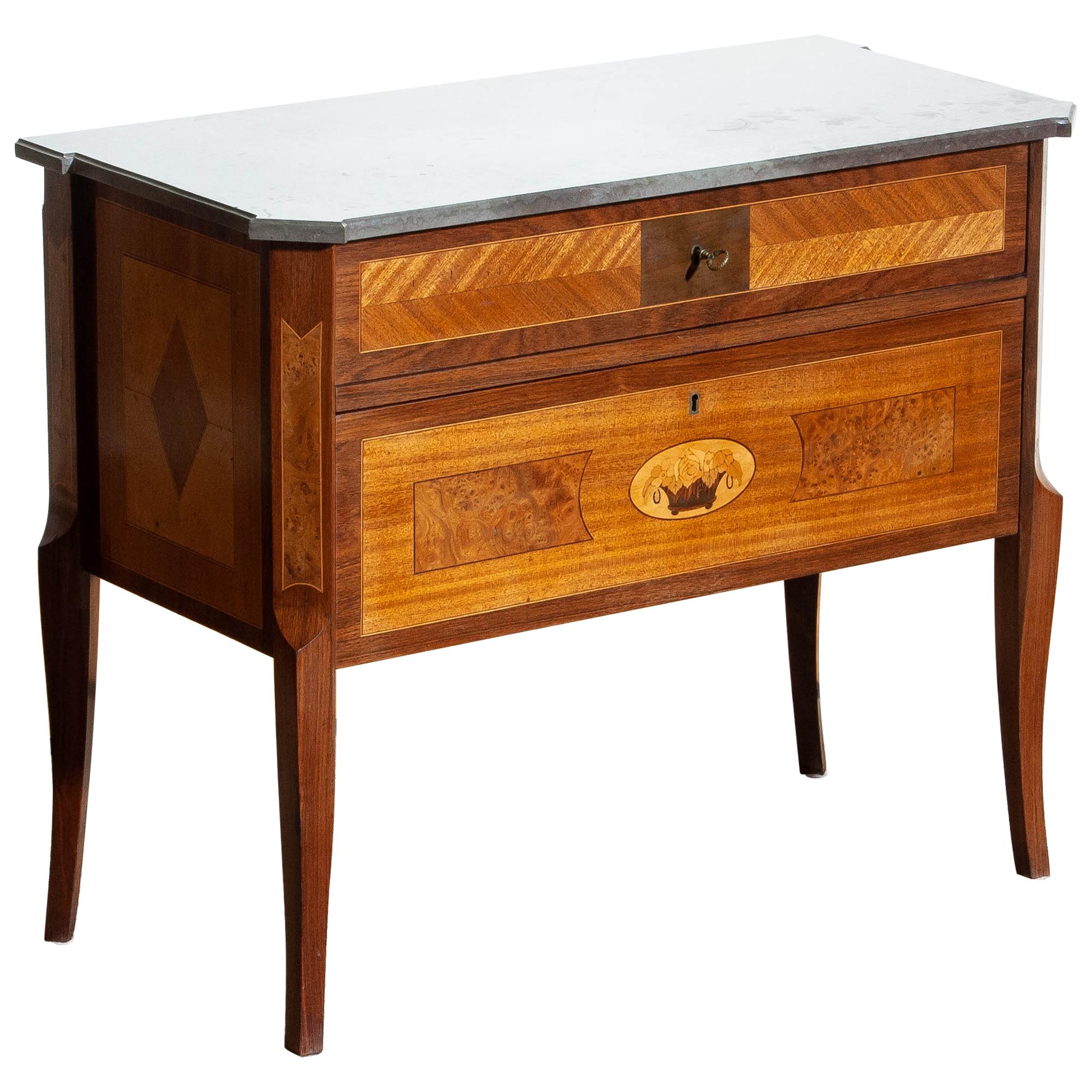 Beautiful commode with large selection of wood craft techniques using mahogany, walnut, birch and various fruitwoods with a Kolmarden top.
Origin: Stockholm, Sweden, circa 1909.
The overall condition is good.
We ship in plywood crates!