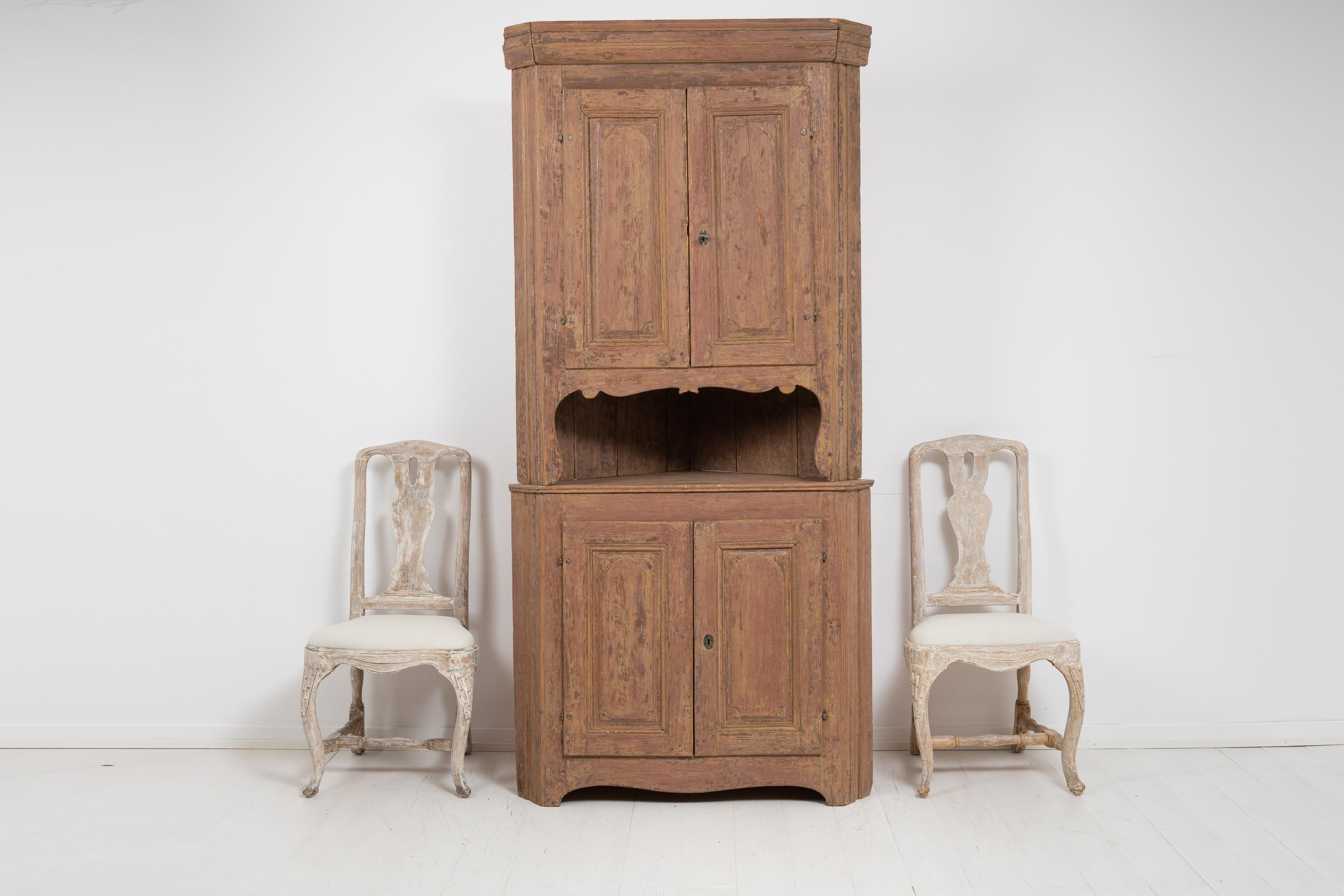 Northern Swedish country neoclassic corner cabinet with the characteristic neoclassical shape. Made in pine around 1800 to 1820, the Swedish neoclassical period is also known as the gustavian period. The cabinet is in 2 parts with old historic paint