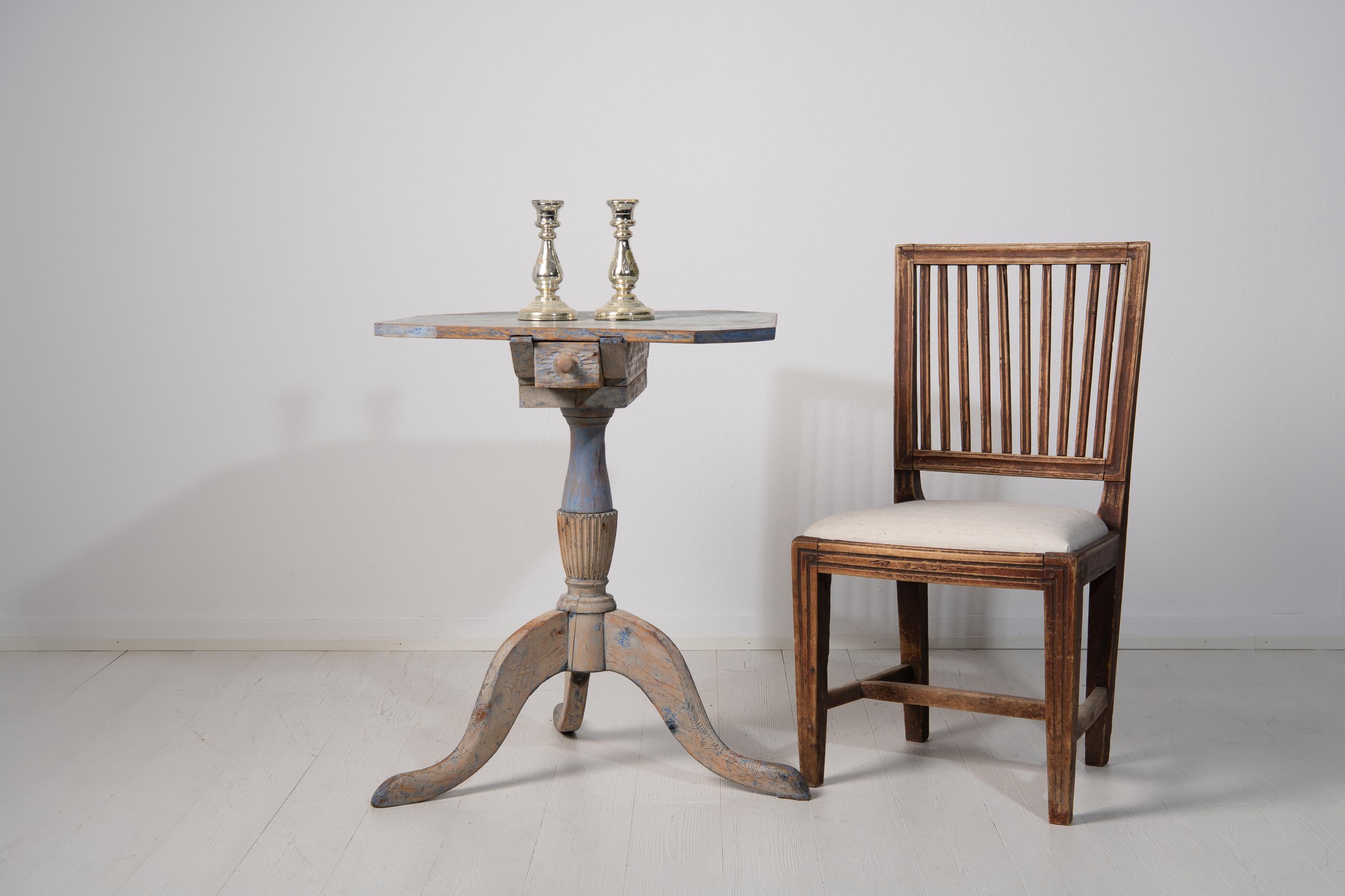 Swedish painted Gustavian column table with a drawer underneath the table top. The table is from northern Sweden and made around 1800 to 1810. The shape of the table top is an added design where it has multiple sides and angels. A smaller table like