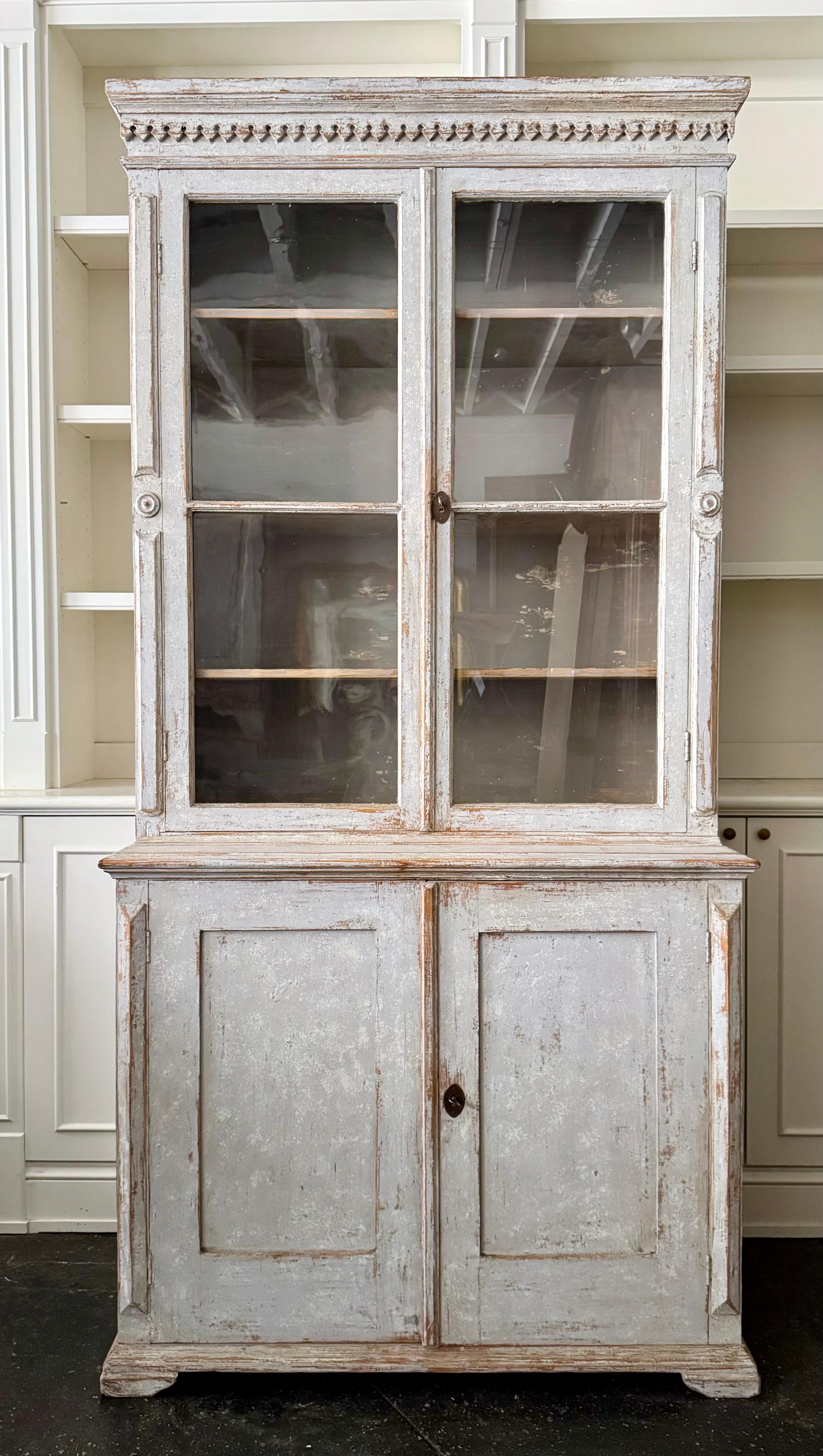 Schwedischer Schrank / Bücherregal / Vitrine mit Glastüren aus dem 19.
Fronten im klassischen Gustavianischen Stil.
Der obere Teil der Bibliothek hat ein geformtes Gesims mit Zahnleisten und drei Regale hinter doppelten Glastüren.
Der Unterschrank