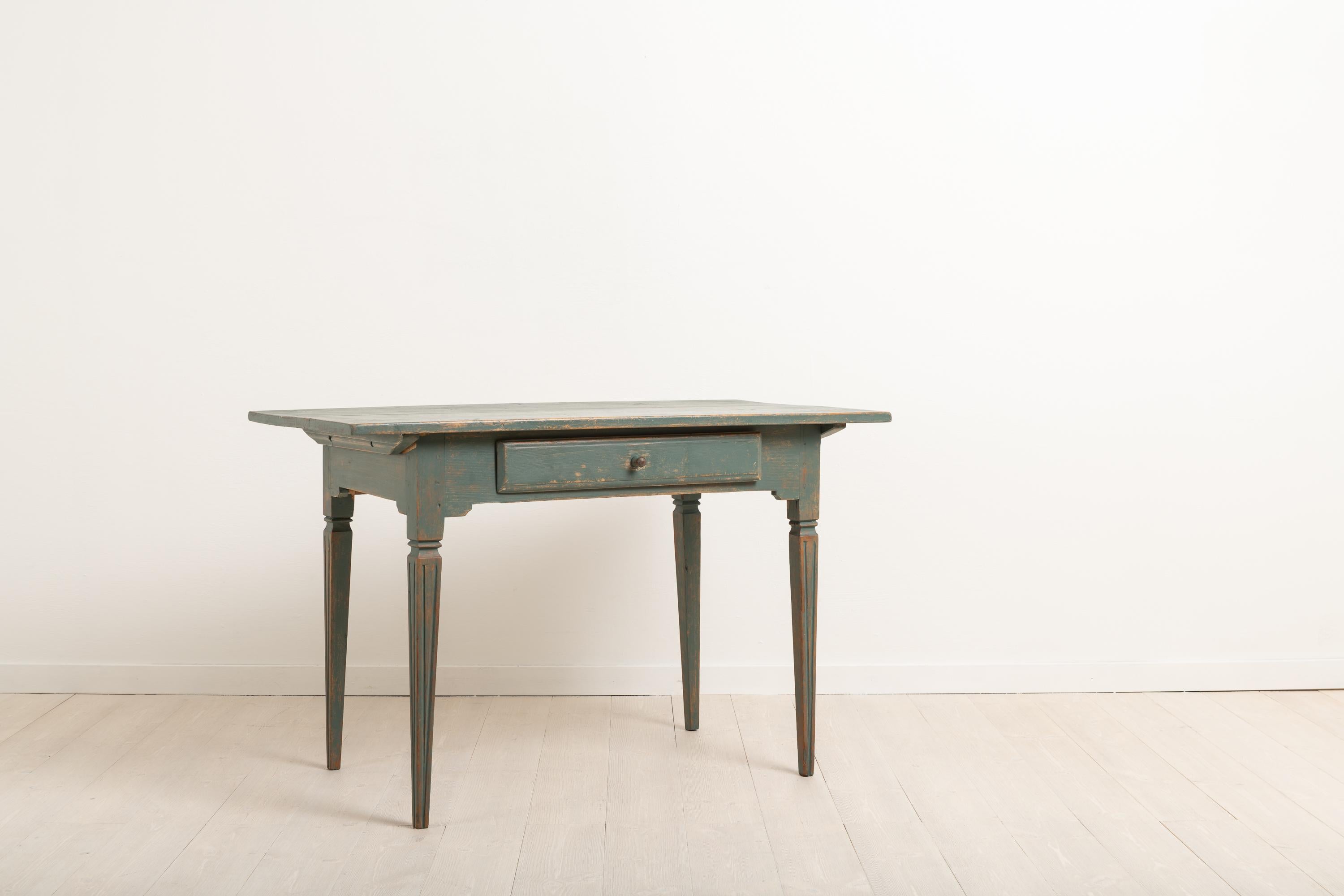 Gustavian side table with straight tapered legs. The legs are decorated with flutes. Distressed dark green paint. The table has a single drawer which has its original wooden knob. Manufactured around 1810-1820 in northern Sweden. The side table is