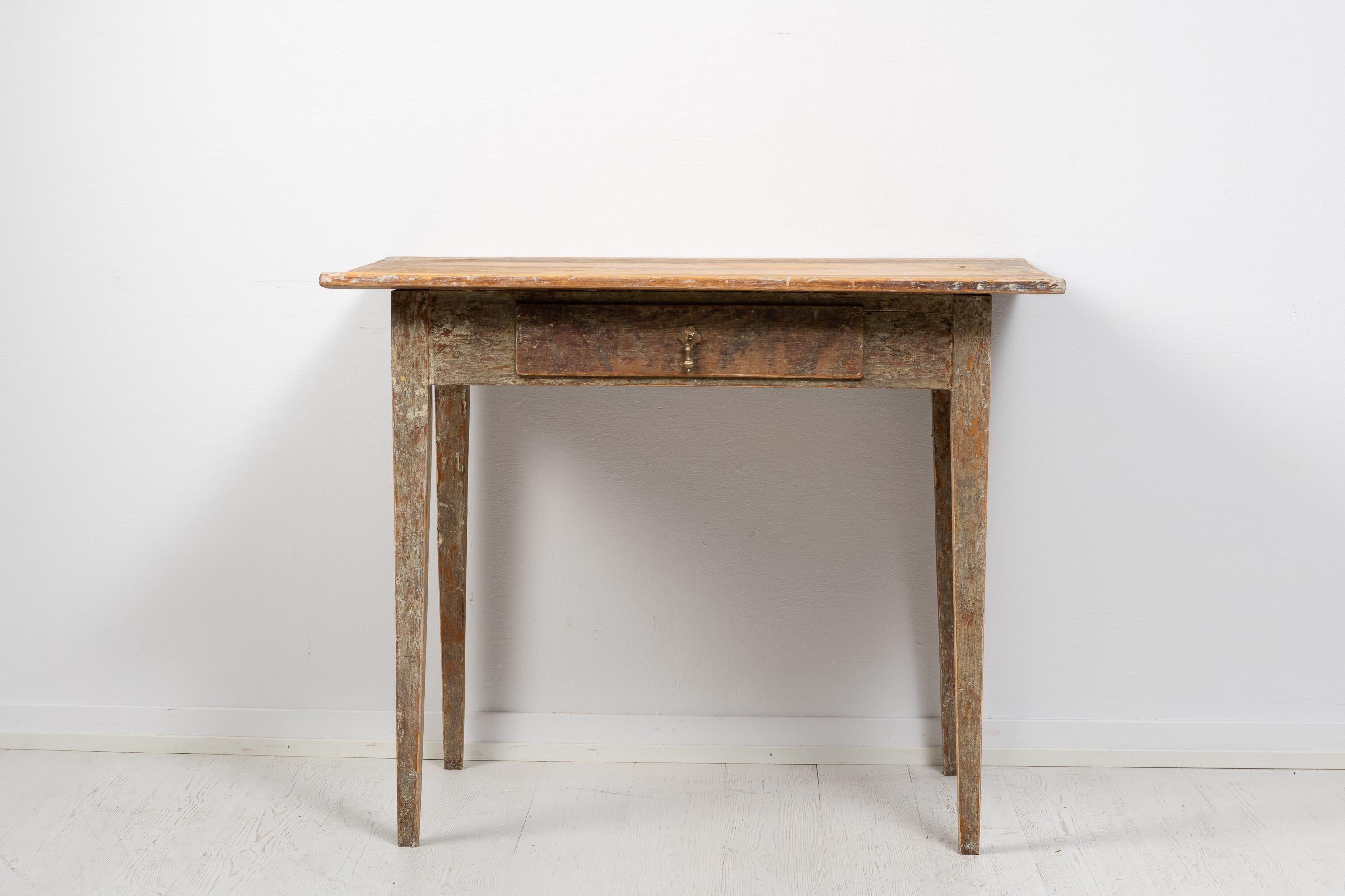 Desk in gustavian style from northern Sweden made during the early 1800s, circa 1820. The desk has straight tapered legs with a single thin drawer. The drawer has an old drawer pull in brass. The desk has been dry scraped by hand to traces of the