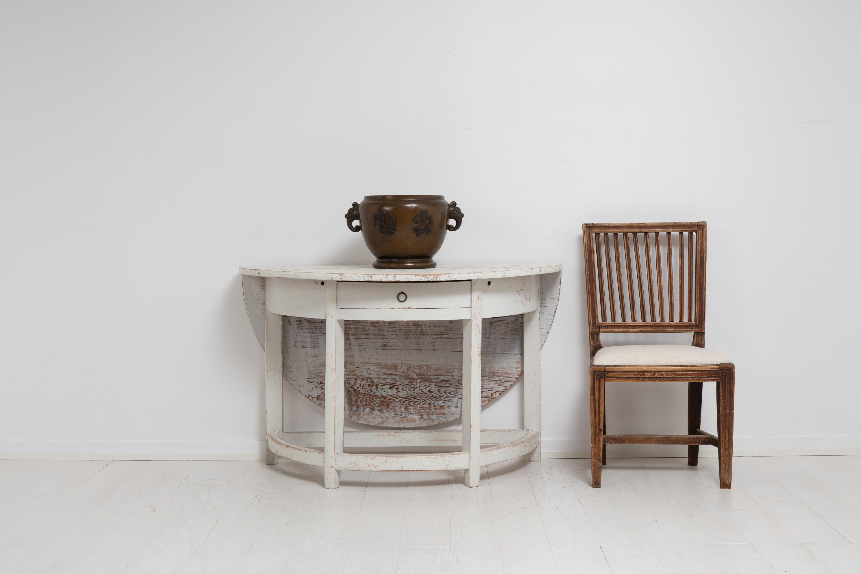 Nordschwedischer Konsolentisch im gustavischen Stil. Der Tisch ist ein schwedisches Landhausmöbel aus dem frühen 19. Jahrhundert, 1810 bis 1820, und er ist ein ungewöhnliches Modell. Die Tischplatte hat eine runde Demi-Lune-Form und auch eine