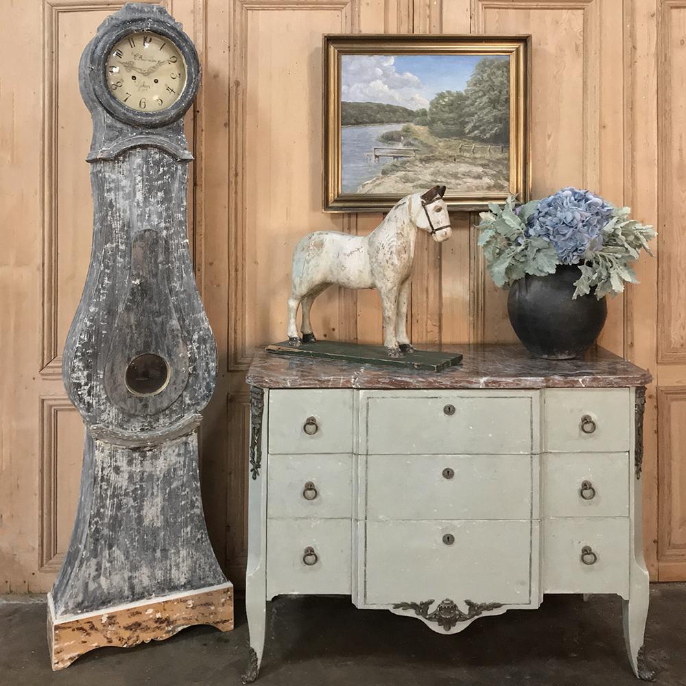 Early 19th century Swedish long case clock is a splendid statement of understated elegance, with tailored yet shapely form, distressed painted finish, and an austere dial design that produces the time in a subtle yet commanding way. Casework is of