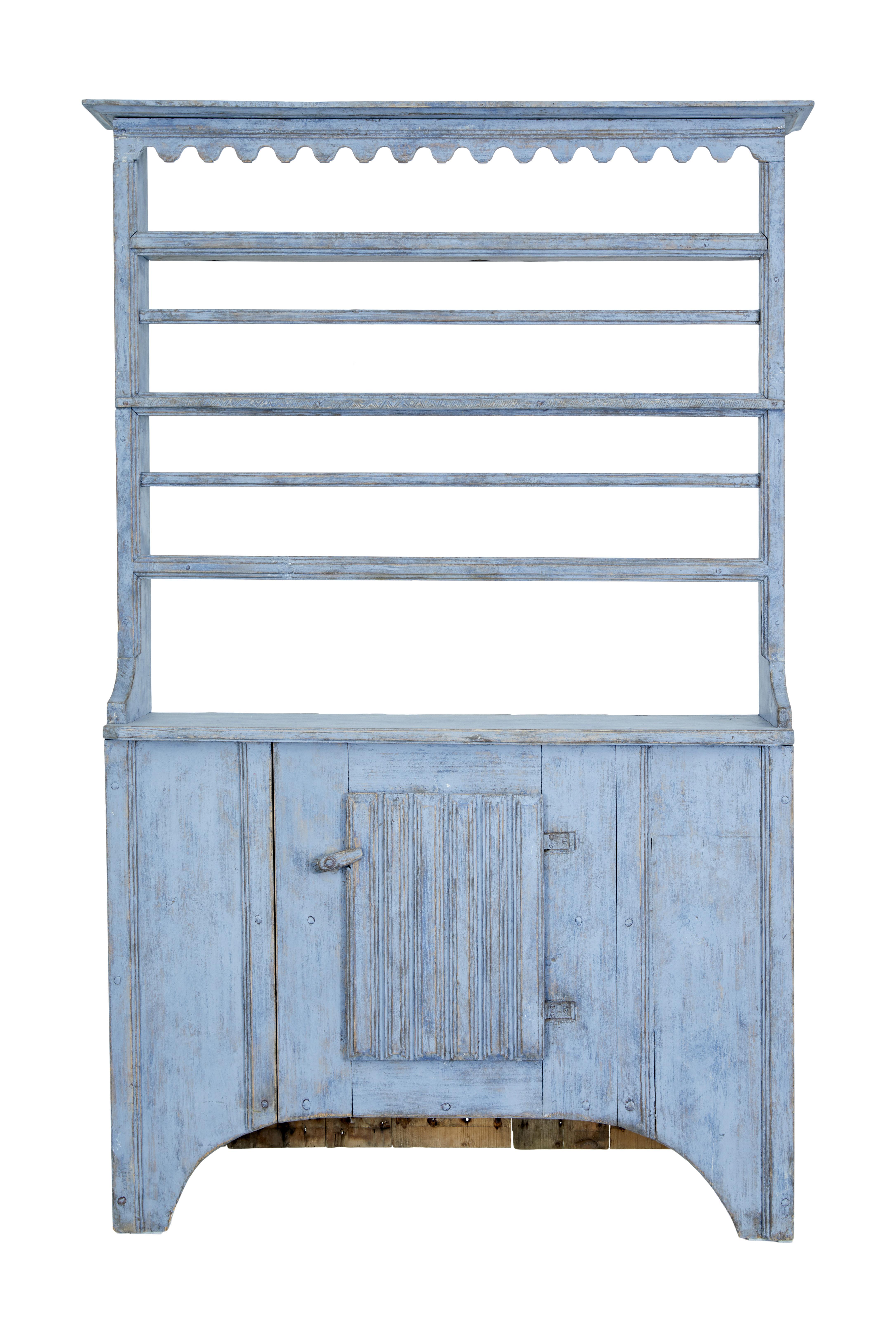 Early 19th century Swedish painted dresser and rack circa 1820.

Beautiful rustic 1 piece cupboard and rack, made in pine and hand painted in a blue wash. Top section with shaped cornice and 3 shelves, 2 with a plate guard and 1 shelf that has a