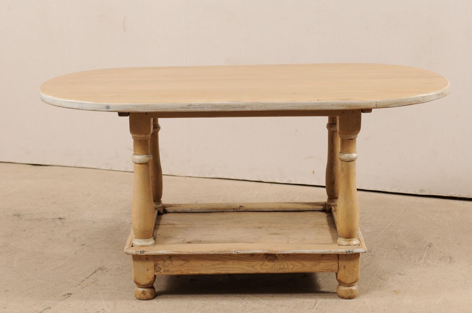 Ein schwedischer, fast ovaler, zweistöckiger Mitteltisch aus dem frühen 19. Jahrhundert. Dieser antike Tisch aus Schweden hat eine meist ovale Platte mit geraden Kanten an den beiden längeren Seiten. Er wird von vier robusten, gedrechselten Beinen