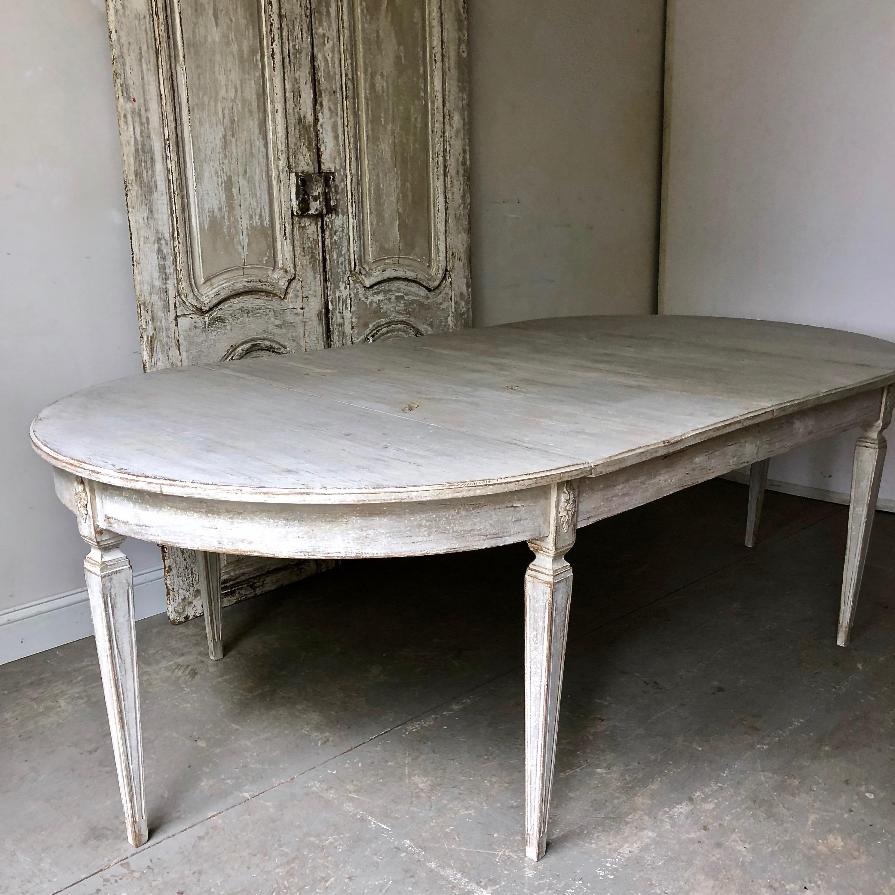 Early 19th century painted Gustavian period extending table with two leaves and tapered legs with flower corner blocks. A practical piece that can be used as round table/ a pair of consoles or extended with one or two leaves up to 94.50