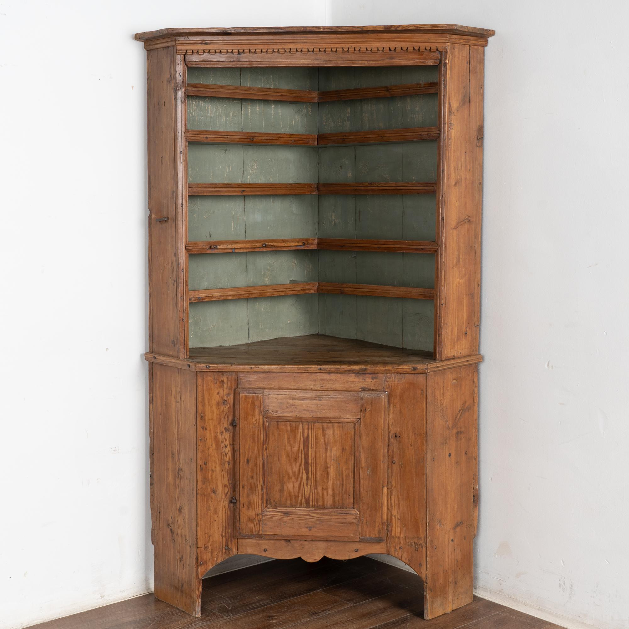 It is the incredible aged patina of the pine that draws one to this traditional Swedish corner cupboard.
The interior is painted a soft green, creating a contrast to whatever you choose to display upon the shelves.
Notice on left side an iron