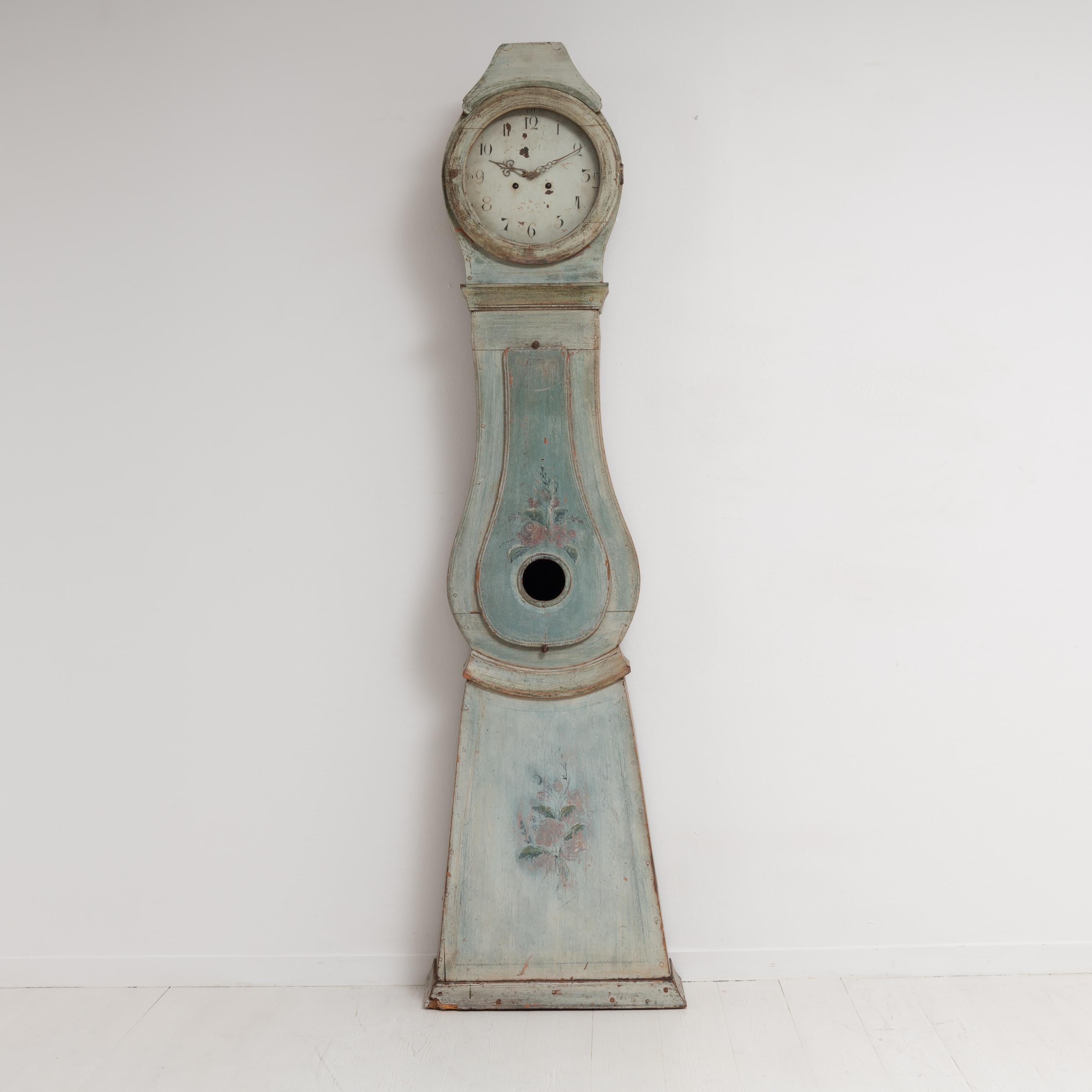 Swedish long case clock from the area Dalarna. Made around 1820 to 1830 with a classic curved rococo shape. The case is unusually charming with the distressed paint. The original paint from the 1820s shines through the later paint from the late